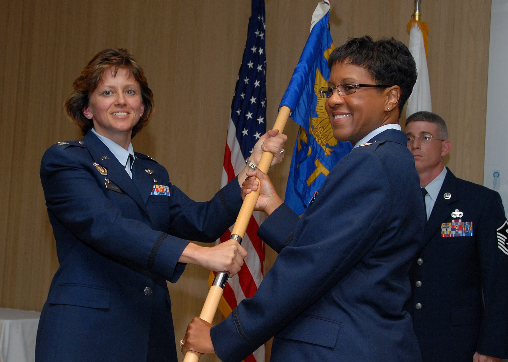 Col. Nancy Dezell, 882nd Training Group commander, hands the guidon to incoming 382nd Training Squadron commander Lt. Col. Subrina Linscomb at the 382nd TRS's change-of-command ceremony July 19. (U.S. Air Force photo/Mike Litteken)