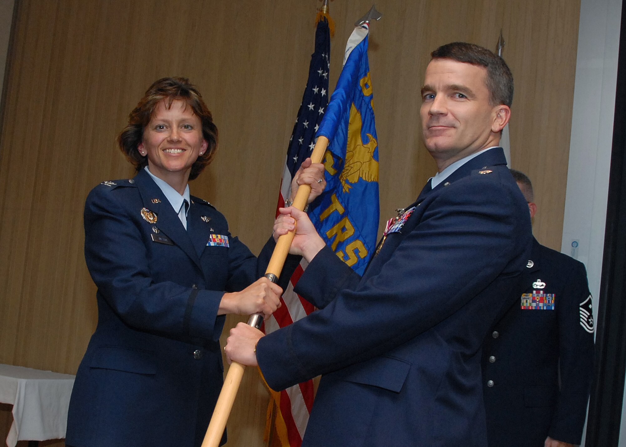 Col. Nancy Dezell, 882nd Training Group commander, takes the guidon from outgoing 382nd Training Squadron commander Lt. Col. London Richard at the 382nd TRS's change-of-command ceremony July 19. (U.S. Air Force photo/Mike Litteken)