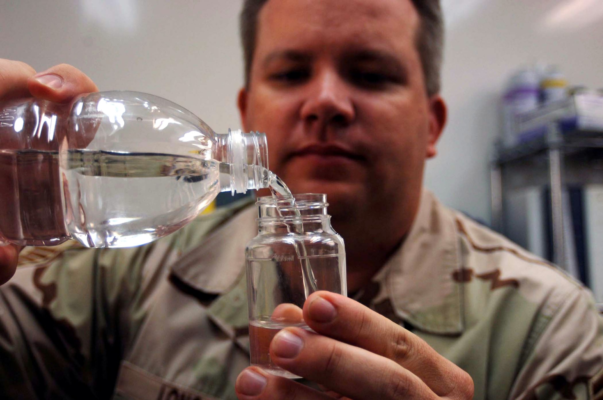 Senior Master Sgt. Ralph Long pours a sample of drinking water into a jar to test for bacteria and E. coli at Sather Air Base, Iraq. Residents at Sather AB use approximately 61,000 one-liter bottles of water every week. That's more than 116,000 gallons, just for potable water. Sergeant Long is assigned to the 447th Expeditionary Medical Squadron. (U.S. Air Force photo/Tech. Sgt. Russell Wicke)