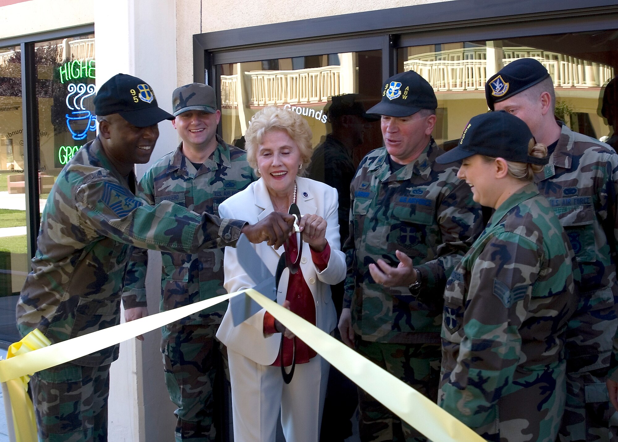 Team Edwards helps Aida O'Connor, Edwards Civilian Military Support Group founder, cut the ribbon during the opening of the Higher Grounds Internet Cafe on July 13. Higher Grounds is a facility designed to give dormitory residents a relaxing, non-alcoholic environment within walking distance. The cafe is broken into three sections -- a theatre room, reading lounge and a general socializing area. It also features plasma televisions, gaming consoles, love seats and wireless Internet. (Photo by Edward Cannon)