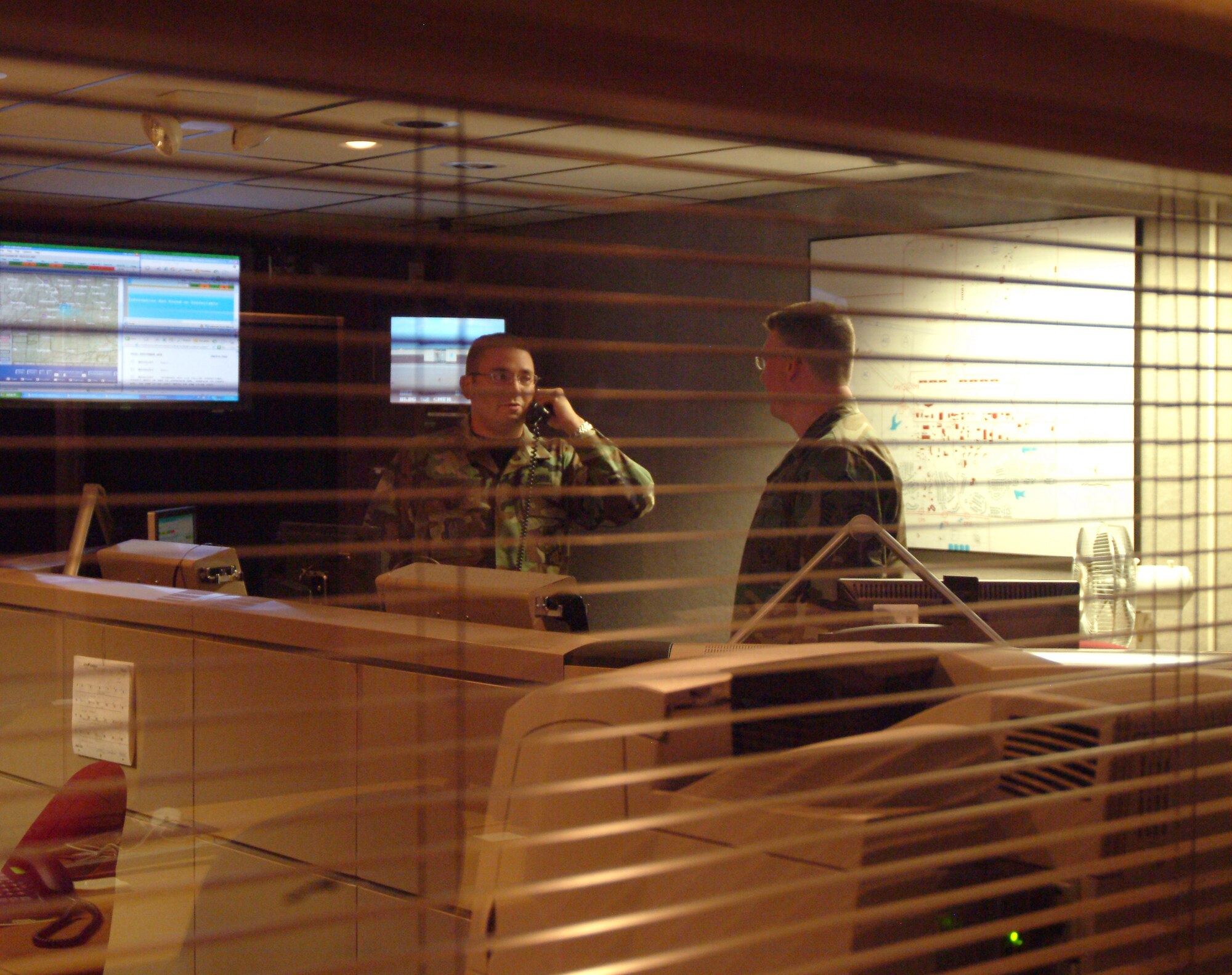 Senior Airman Adrian Walker, command post journeyman and the Air Force Reserve Command's Airman of the Year in Command and Control for 2004, relays incoming information to Senior Master Sgt. Tony Fleming, command post superintendent.  The 442nd Fighter Wing's command post is the clearing house for much of the information coming in and leaving the wing.  It is a hive of activity during exercises, contingencies and every day events.  (U.S. Air Force photo/Master Sgt. William Huntington)