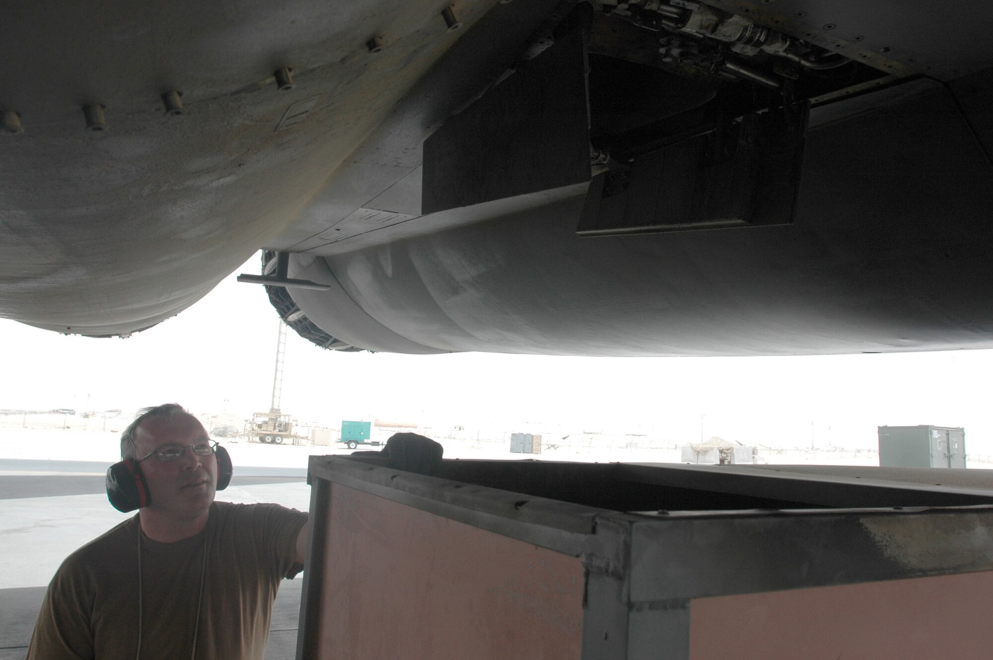 Master Sgt. Paul Bumann, 379th Expeditionary Aircraft Maintenance Squadron weapons section shift supervisor and a St. Louis native, positions an auxillary power unit deflector sheid under a B-1. The shield helps direct heat away from maintainers and the flightline, keeping Airmen healthy and saving the Air Force money. (U.S. Air Force photo by Senior Airman Clark Staehle)