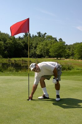 HANSCOM AFB, Mass., -- Karl Farmer retrieves his “golden shot” after making a hole-in-one on the Par 3, third hole at the Patriot Golf Course July 12. (U.S. Air Force photo by Walter Santos)