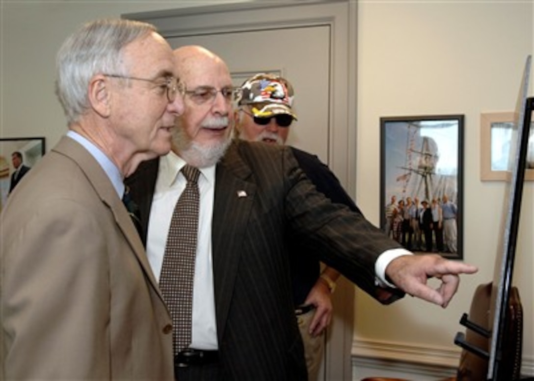Robert Rosenthal (2nd from left) founder and financier of the "Spirit of America Tour," which brings top entertainers to military bases to entertain our troops, points out some interesting photos in a poster advertising a concert by the Charlie Daniels Band to Deputy Secretary of Defense Gordon England (left) in the Pentagon on July 16, 2007.  Charlie Daniels (right), who often performs in the "Spirit of America Tour," accompanied Rosenthal on his visit.  England presented Rosenthal the Department of Defense Medal for Distinguished Public Service in recognition of all he has done for the men and women of the U.S. armed forces.  