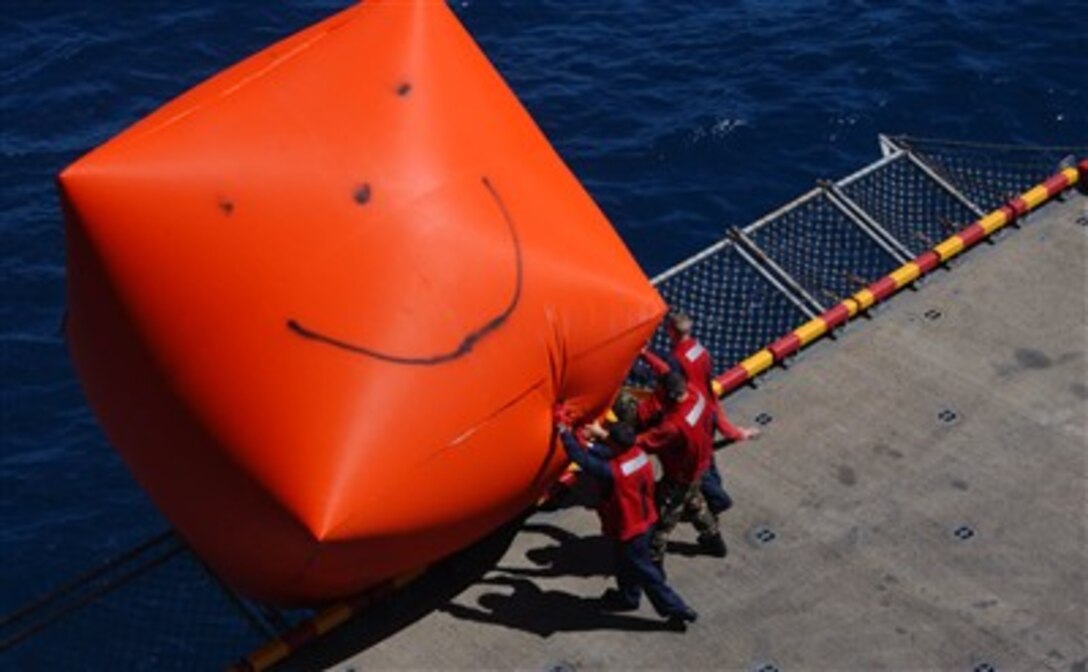 U.S. Navy sailors push an inflatable target emblazoned with a giant happy face overboard from the USS Boxer (LHD 4) as the ship operates in the Pacific Ocean off the coast of Southern California on July 13, 2007.  The floating target will be used for gunnery practice.  