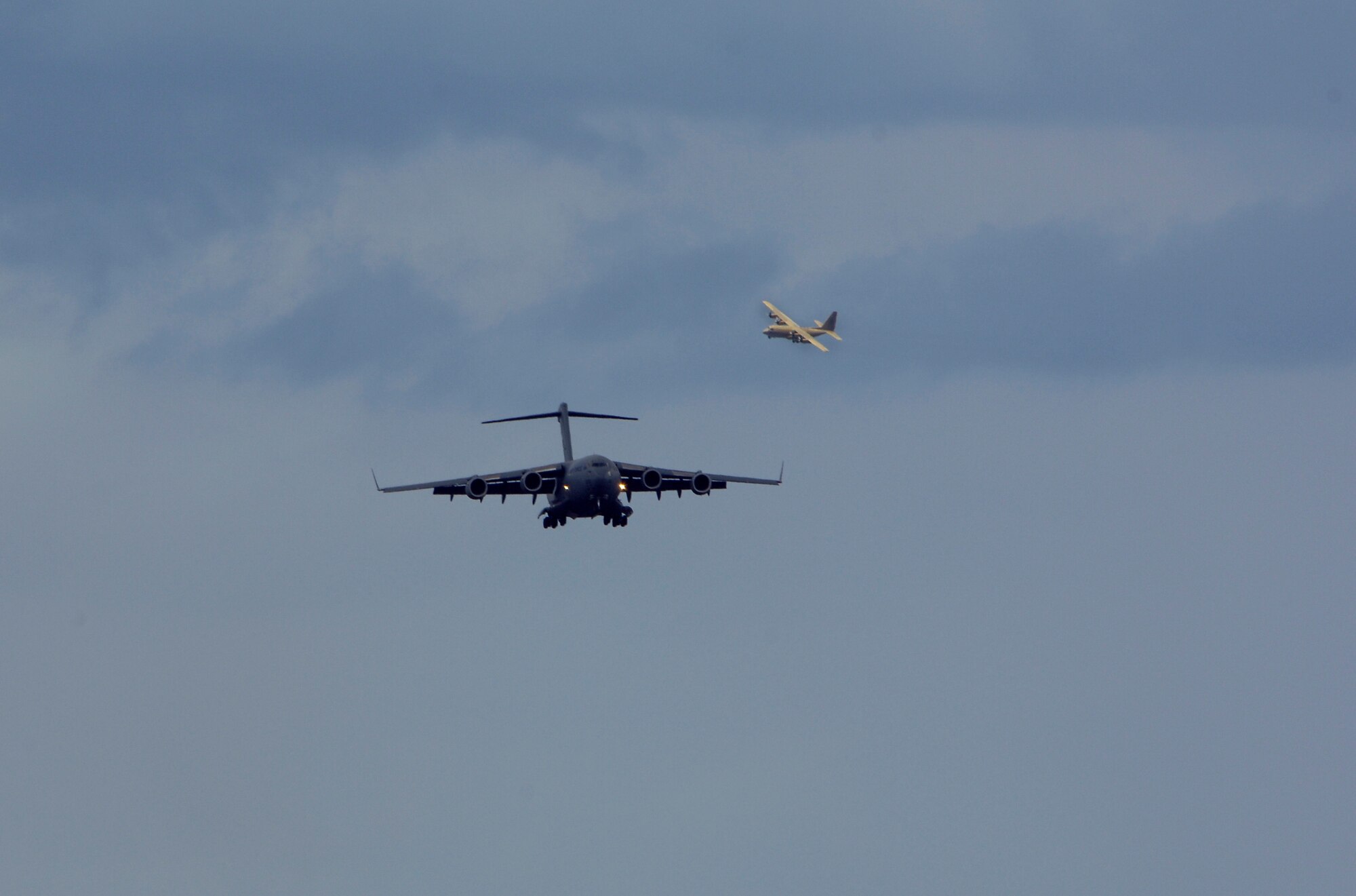A C-17 Globemaster III prepares to land at McChord Air Force Base as a Royal Saudi Air Force C-130 queues up behind it, McChord AFB, Wash., July 19, 2007.  Air Mobility Command's Rodeo 2007 is a readiness competition of U.S. and international mobility air forces.  It focuses on improving warfighting capabilities and support of the Global War on Terrorism.  (U.S. Air Force photo by Tech. Sgt. Maria J. Bare) (Released)
