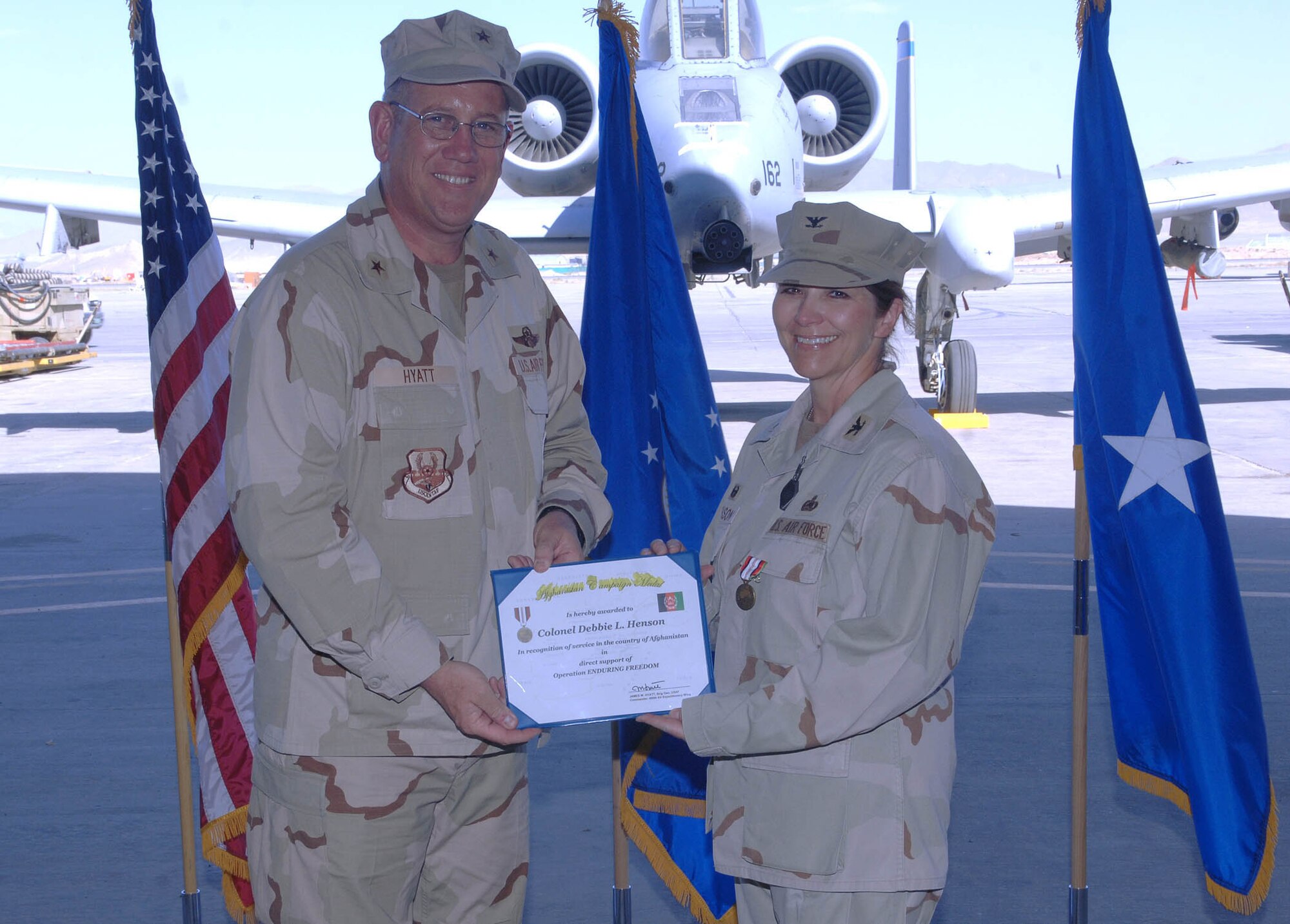 Brig. Gen. Bill Hyatt (left), 455th Air Expeditionary Wing commander, presents Col. Debbie Henson, 455th Expeditionary Mission Support Group commander, with the Afghanistan Campaign medal in a change of command ceremony June 18 at Bagram Airfield, Afghanistan. (U.S. Air Force photo by Staff Sgt. Craig Seals)