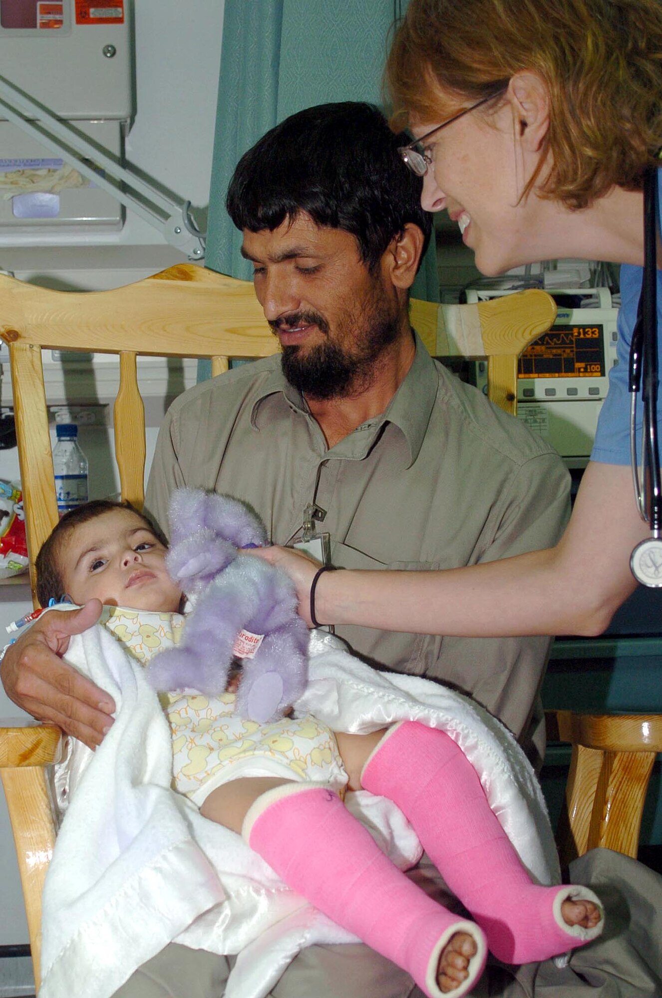 Air Force Dr. (Maj.) Sheralyn Wood, Task Force Med pediatrician, shows nine-month old Salma, the sole survivor of an IED explosion that left her orphaned, a stuffed animal, while her maternal-uncle Mohammad Saber holds her. Salma is the sole-survivor of an IED explosion that left her severely injured and orphaned. She has been under the care of the Craig Joint-Theater Hospital medical staff at Bagram Airfield, Afghanistan, since July 5. (U.S. Air Force photo by Senior Airman Dilia DeGrego)