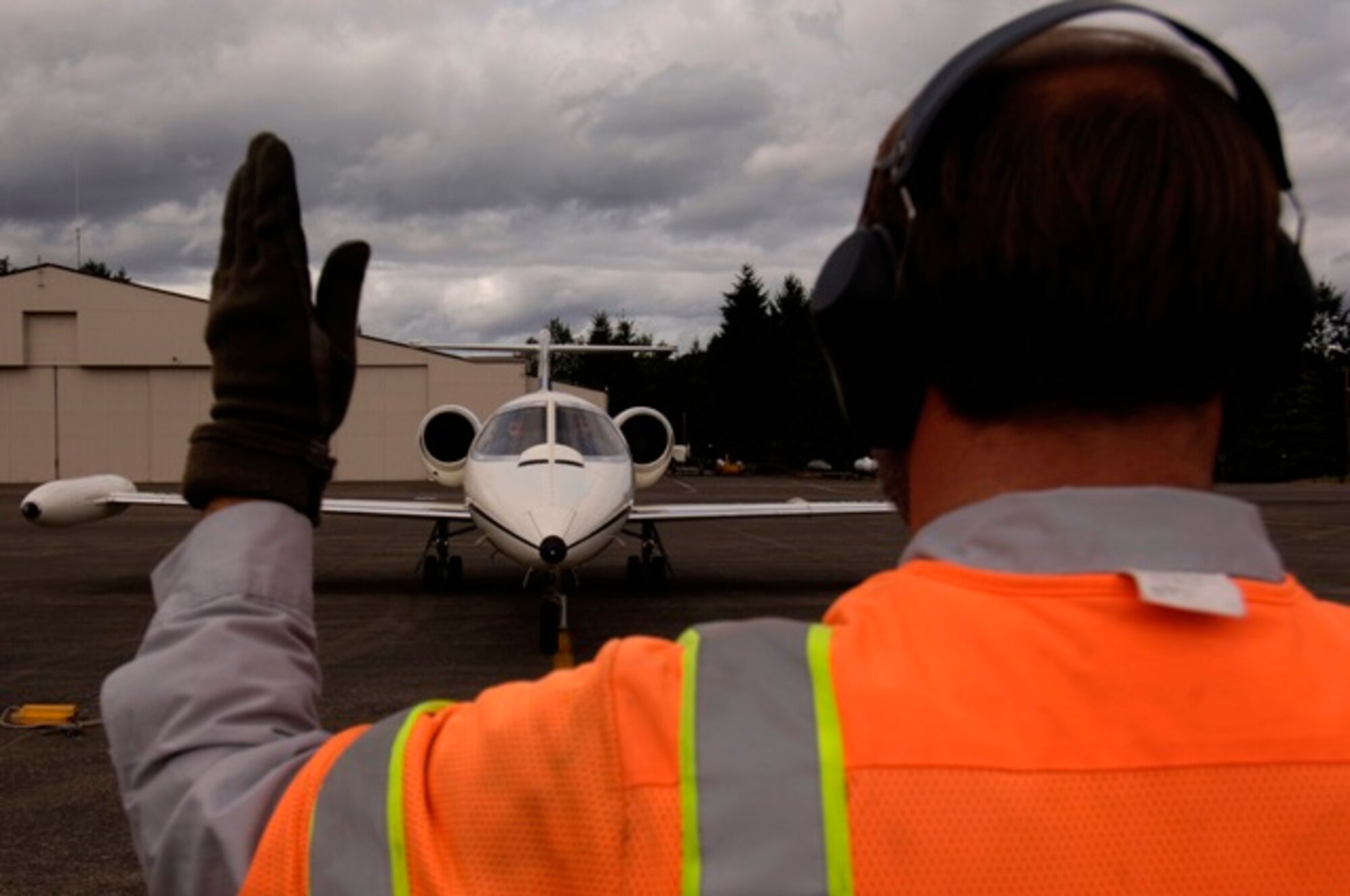 A U.S. Air Force C-21 aircraft from the 311th Airlift Squadron at Peterson Air Force Base, Colo., is marshaled into McChord AFB, Wash., July 21 to participate in Rodeo 2007. Air Mobility Command's Rodeo 2007 is a readiness competition of U.S. and international mobility air forces. It focuses on improving warfighting capabilities and support of the Global War on Terrorism. (U.S. Air Force photo/Tech. Sgt. Adrian Cadiz)