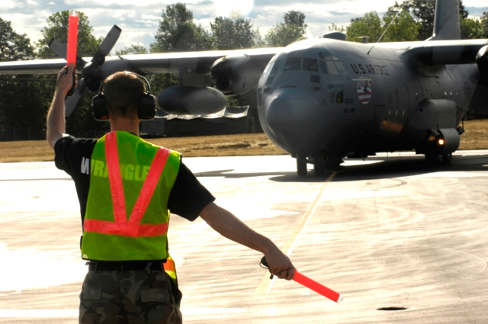 Senior Airman Christian Recene marshals a C-130 from Ramstien Air Base, Germany, during their arrival to Rodeo 2007 at McChord Air Force Base, Wash., July 21. Rodeo 2007, hosted by Air Mobility Command, is a readiness competition of U.S. and international mobility air forces. It focuses on improving warfighting capabilities and support of the Global War on Terrorism. (U.S. Air Force Photo/Airman Jonathan Olds)