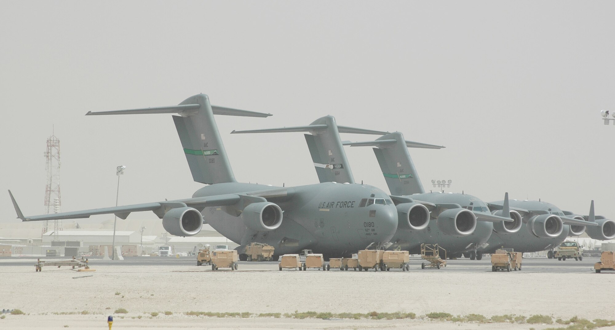 C-17 Globemaster IIIs await fuel, freight and flight crews at a forward deployed location. C-17s contributed to 141 coalition airlift sorties and moved approximately 450 people around the area of responsibility July 21. (U.S. Air Force photo/Senior Airman Clark Staehle) 