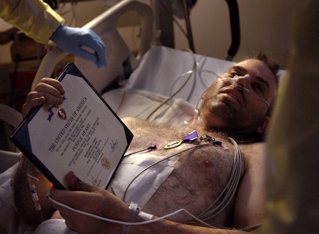 U.S. Army Maj. Daniel Dudek is presented the Purple Heart medal at his bedside by the U.S. Marine Corps Gen. Peter Pace, chairman of the Joint Chiefs of Staff, at Landsthul Regional Medical Center, Germany, July 21, 2007.  Landstuhl is the largest American hospital outside the United States.