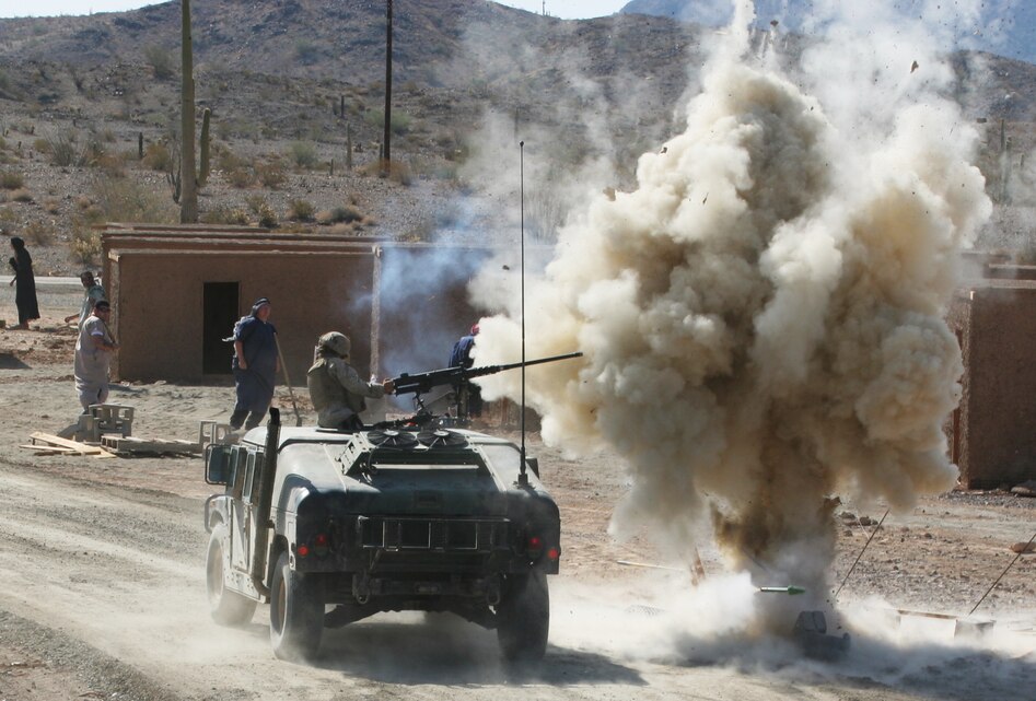A simulated improvised explosive device hurls a cloud of earth into the air sending a Marine reeling backwards in her turret during improvised explosive device and escalation of force training July 22, at the U.S Army Yuma Proving Ground in Arizona. Marines and sailors with Combat Logistics Battalion 11 attended an arduous week-long training evolution designed to prepare the battalion for a deployment to a combat zone.