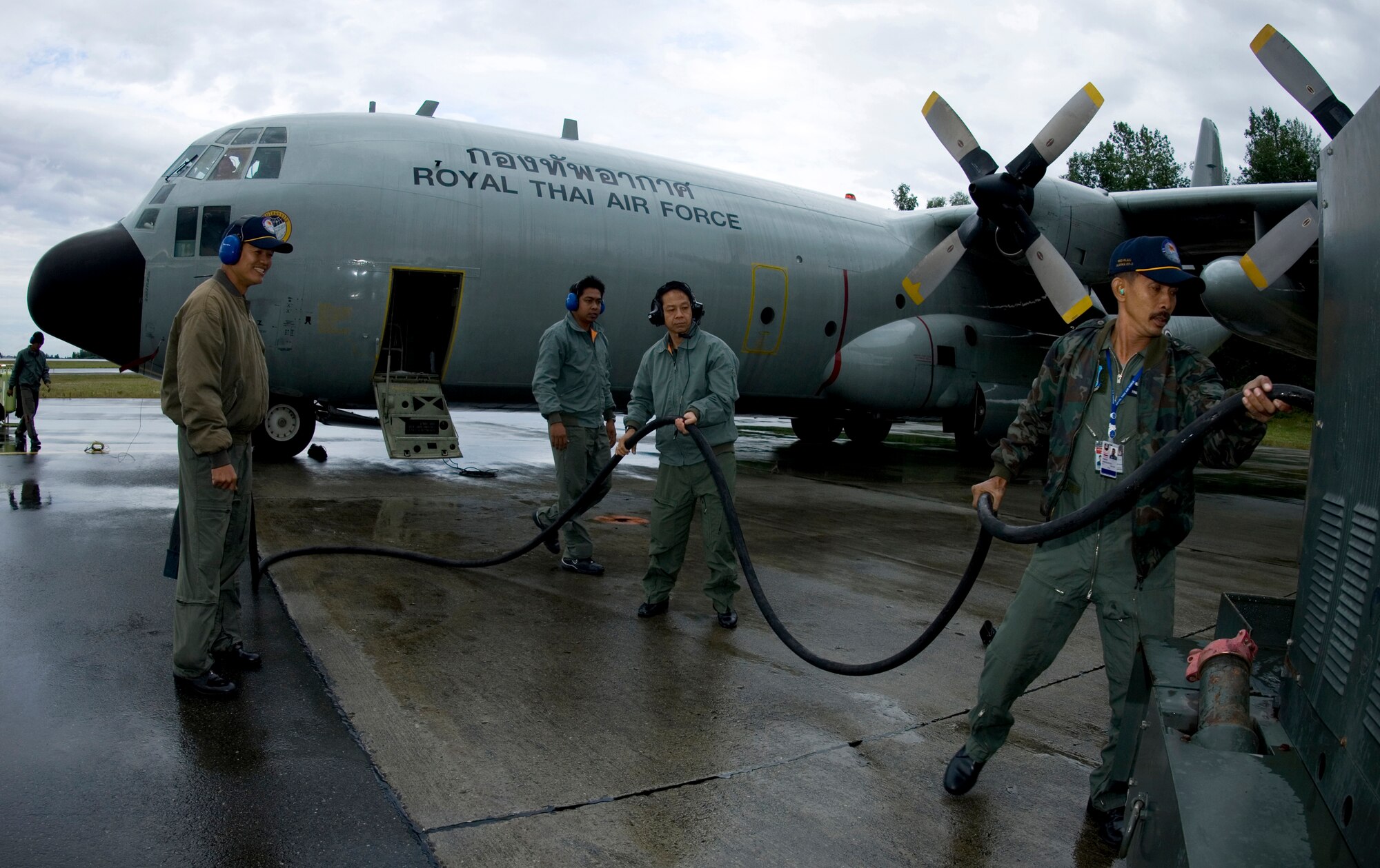 ELMENDORF AIR FORCE BASE, Alaska - C-130 maintainers with the Royal Thai Air Force work through their pre-flight maintanence checks on the rain soaked runway here during Red Flag-Alaska 2007. (U.S. Air Force Photo by Senior Airman Garrett Hothan)