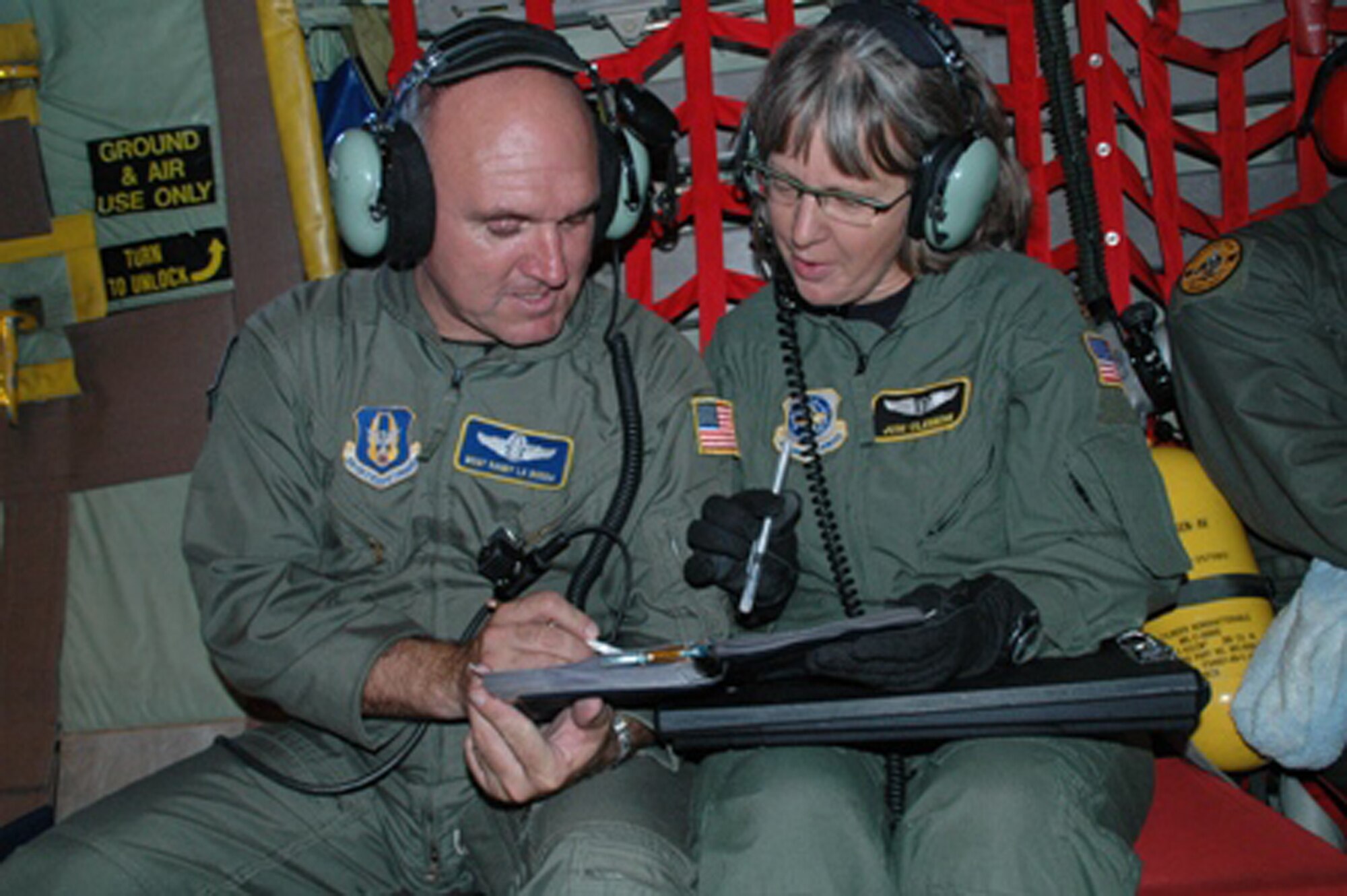 Master Sgt. Randall Labodda confers with Maj. Joni Clemens during an aeromedical training flight on July 19.  Major Clemens, with the 43rd Aeromedical Evacuation Squadron at Pope Air Force Base, N.C., served as the medical crew director.  Sergeant Labodda is a loadmaster with the Air Force Reserve Command's 440th Airlift Wing.  The flight was one of the first operational missions for the 440th AW from its new location at Pope AFB.  The Reserve unit moved to North Carolina from Wisconsin in June. (U.S. Air Force photo/Maj. Ann Knabe)