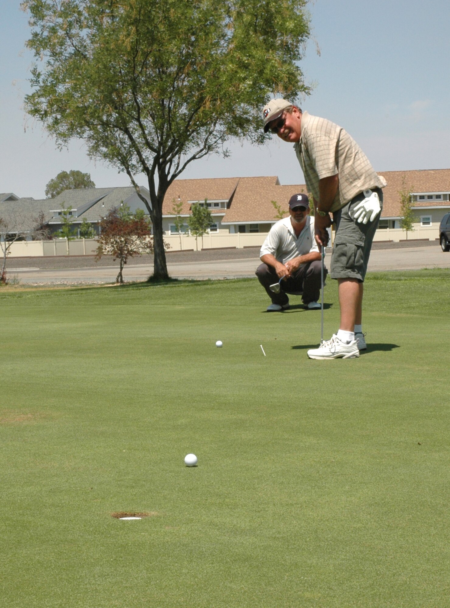 MOUNTAIN HOME AIR FORCE BASE, Idaho -- Gary Compton, 366th Civil Engineer Squadron attempts to make a put while Dave Kinney, 366th CES, watches at the Silver Sage golf course here during the Air Force ball golf tournament July 20. The tournament raised almost $600 to support this year's ball. (U.S. Air Force photo/Airman Samantha S. DeVries)