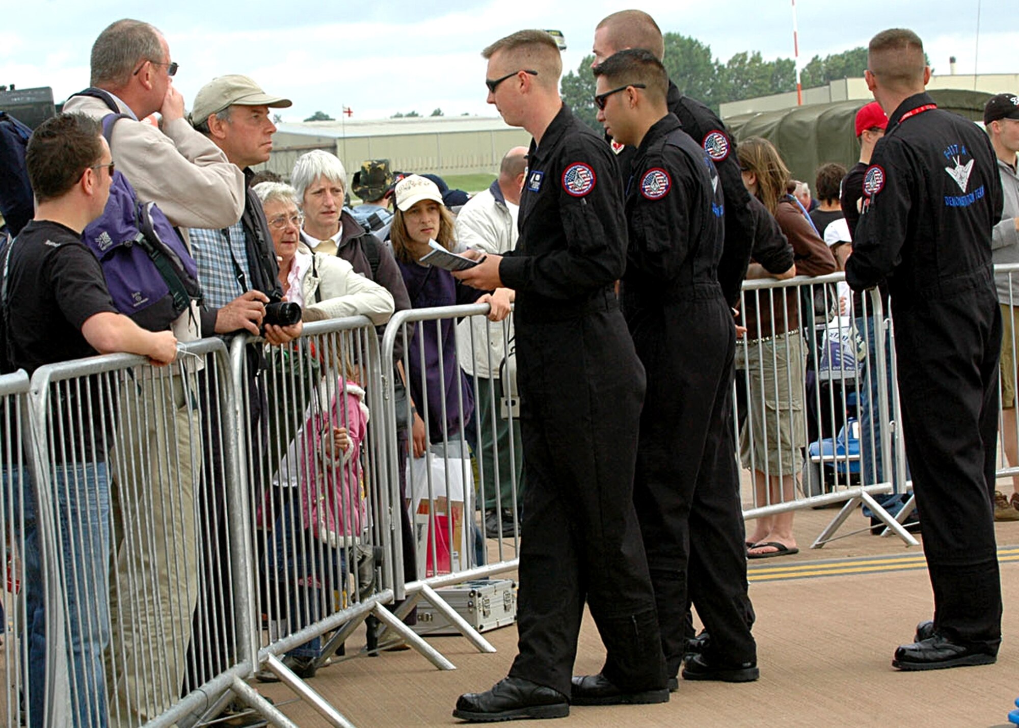 F-117 Demonstration Team members Staff Sgts. Jason Yeargin, Oscar Vega, Jody Daniels and Brian Donovan answer questions, have their picturs taken and sign autographs for throngs of spectators who flocked around the Nighthawk static display July 14 during the Royal International Air Tatoo at Fairford, United Kingdom. Holloman sent two F-117As and a 22-person team of pilots and support crew to the international air show. (U.S. Air Force photo/ Mr. Tommy Fuller)
