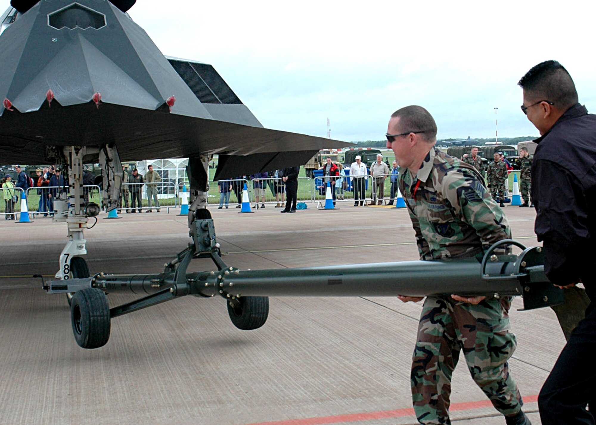 Staff Sgt. John Hopkins, 49th Maintenance Squadron, assists F-117 Demo Team member Staff Sgt. Santos Montalvo to disconnect the tow boom from an F-117A during set up of a static display for an international air show at Fairford, United Kingdom on July 14. (U.S. Air Force photo/ Mr. Tommy Fuller)