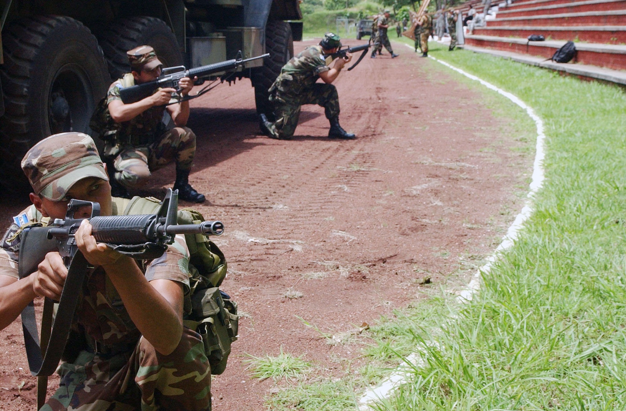 El Salvadorian soldiers provide force protection as their medical personnel transport wounded soldiers to a simulated triage facility. During a week-long training mission, soldiers were taught force protection measures, convoy defense skills and improvised explosive device detection, to prepare them for their upcoming deployment in support of Operation Iraqi Freedom. (U.S. Air Force photo/Senior Airman Shaun Emery)
