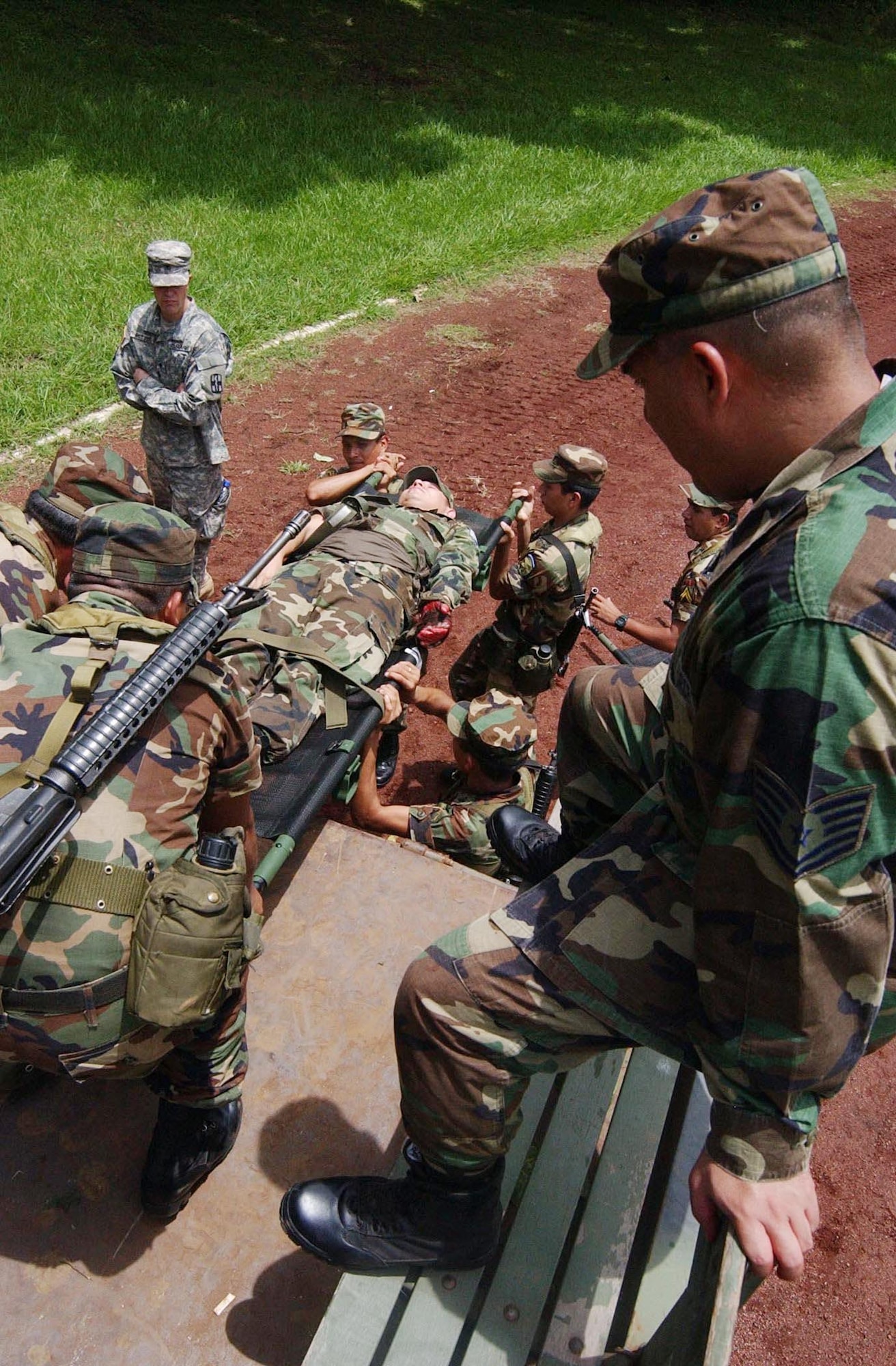 Medical instructor Tech. Sgt. James Luna observes El Salvadorian soldiers as they offload a wounded soldier from the back of a five-ton truck. During a week-long training mission, medical students were taught combat life saver skills in preparation for their deployment in support of Operation Iraqi Freedom. (U.S. Air Force photo/Senior Airman Shaun Emery)