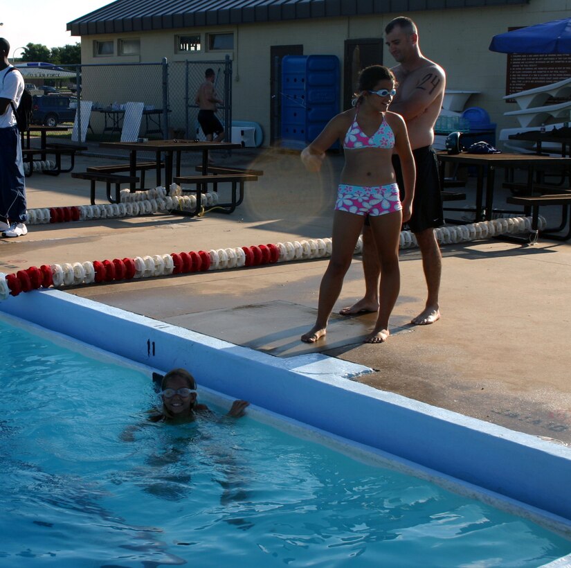 Katie Alfred prepares to swim her laps as sister Fiama Alfred and father Mike Young look on.  Katie won first place in the female youth division of the 82nd Services Squadron's mini-triathalon July 21. (U.S. Air Force photo/Staff Sgt. Tonnette Thompson)