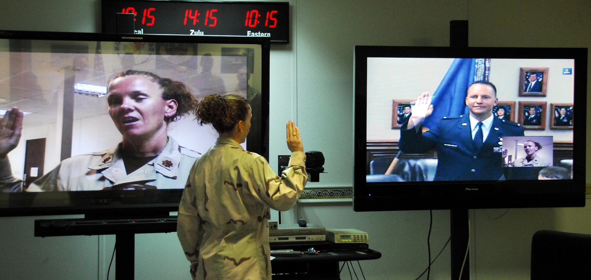 SOUTHWEST ASIA -- Maj. Eileen LaBrecque, administers the oath via video teleconferencing to her husband, Capt. Craig LaBrecque, 36th Electronic Warfare Squadron, from the Combined Air and Space Operations Center here.  The major used the VTC to administer the oath of enlistment to her husband, Craig, who pinned on captain during the promotion ceremony July 16.  (U.S. Air Force photo by Tech. Sgt. Scott Moorman.)