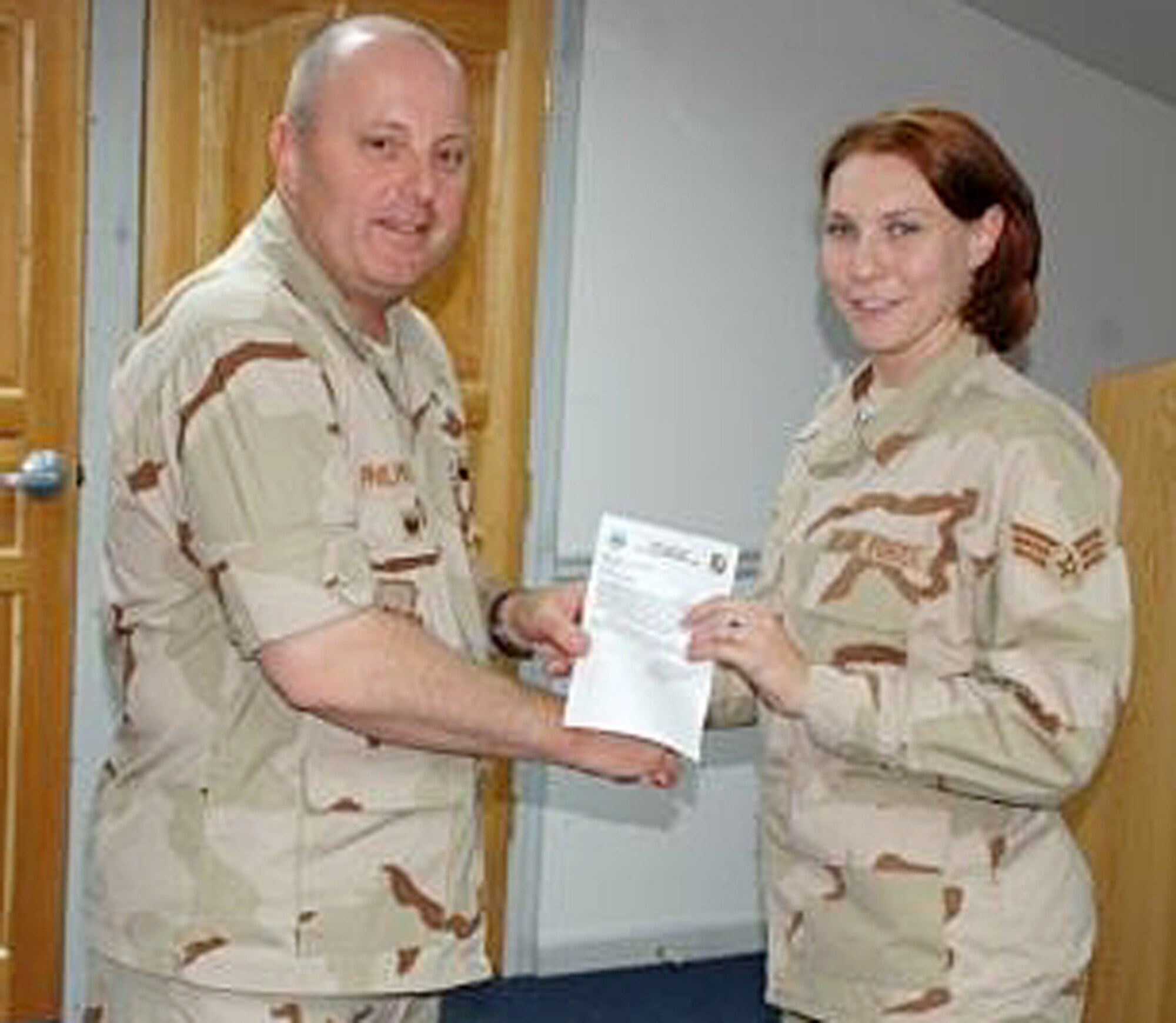 Senior Airman Tess Kelley, 14th Comptroller Squadron, receives a congratulatory letter from Col. Tom Philipkosky, 376th Air Expeditionary Wing vice commander, for being the June Rotational Performer of the Month. She was no. 1 out of 13 customer service and support technicians up for the award. (U.S. Air Force Photo)