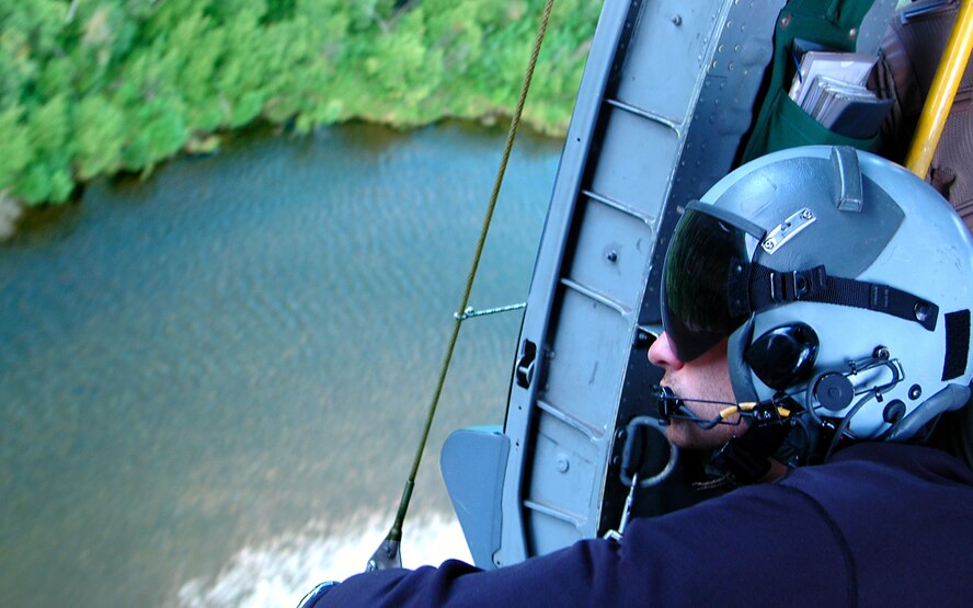 A pararescueman keeps watch out the side door of an HH-60 Pave Hawk helicopter en route to a combat search and rescue training scenario at Red Flag-Alaska 07-3, a multinational air combat training exercise held at the Pacific Alaska Range Complex.  The Pave Hawk and crew are with the 210th Rescue Squadron from Kulis Air National Guard Base, Alaska. (U.S. Air Force photo/Staff Sgt. Shawn J. Jones) 