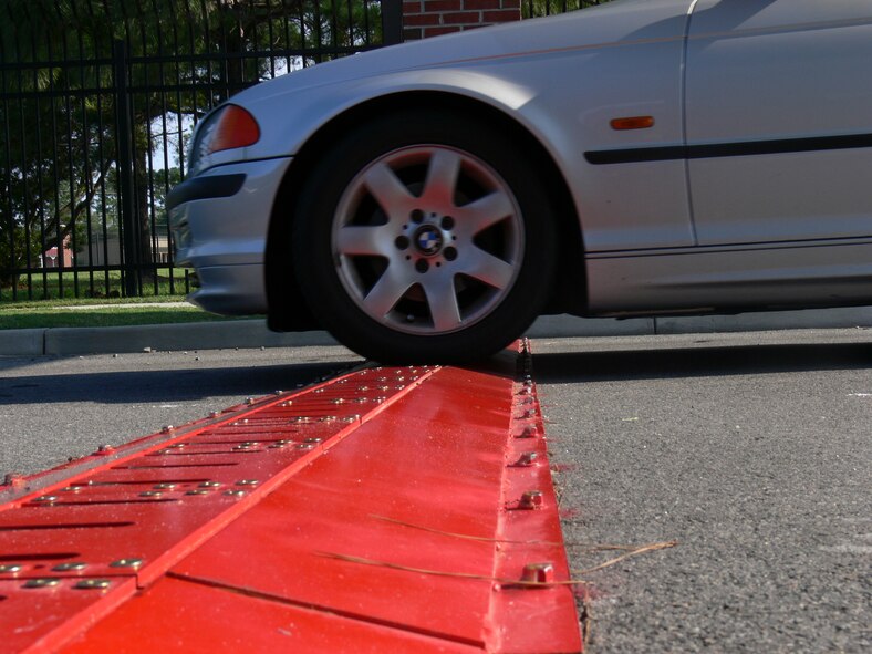 A vehicle drives over a deactivated set of ‘Tiger Teeth’ as it exits Moody Air Force Base’s South Gate July 23. When activated, the anti-vehicle barriers will puncture the tires of any vehicle traveling against the normal flow of traffic. (U.S. Air Force photo by Tech. Sgt. Parker Gyokeres)