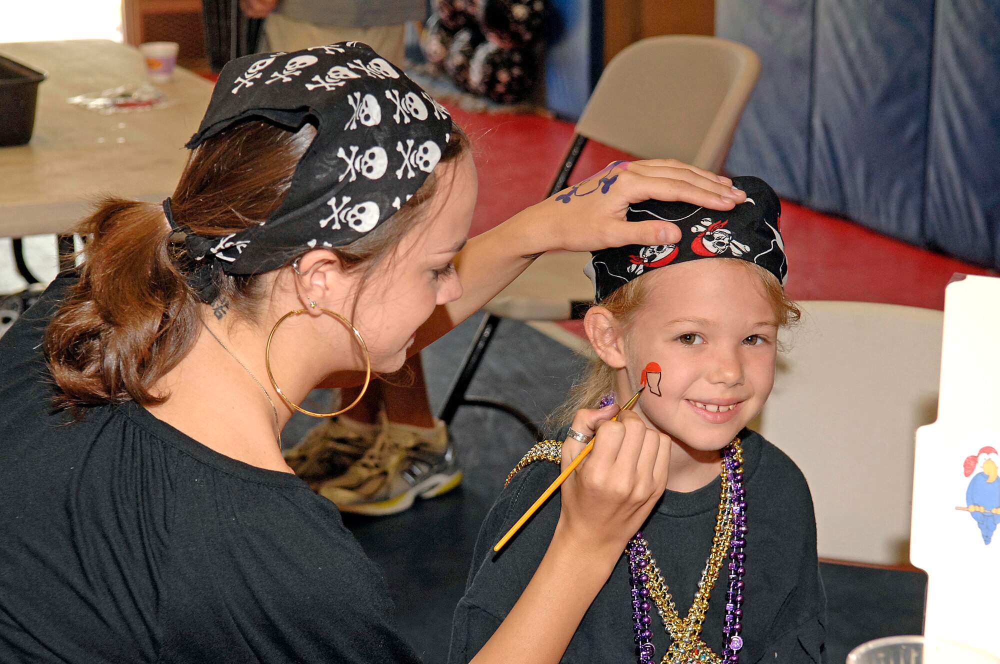 EGLIN AIR FORCE BASE, Fla. -- Courtney Craighead paints a face on Mary Brannon's face at the Youth Center July 20.  Face painting was just one event as the base library continues its pirate theme during the summer-long reading program. (Air Force photo by Bruce Hoffman.)

