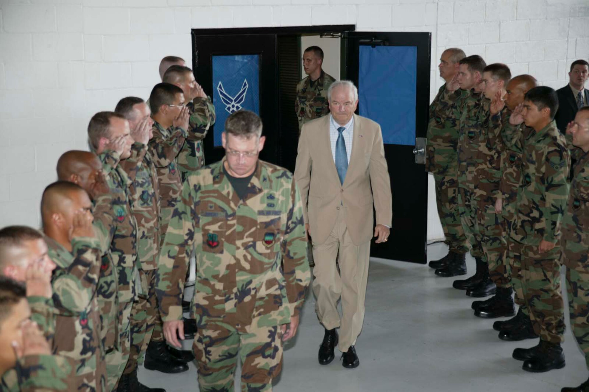 SHAW AIR FORCE BASE, S.C.-- Col. Robert Hopkins, 20th Maintenance Group commander, escorts Secretary of the Air Force Michael W. Wynne on stage as a detail of Airmen salute at an Airman's call here July 19. Mr. Wynne toured the 20th Fighter Wing prior the Airman's call. The Secretary of the Air Force is responsible for the affairs of the Department of the Air Force, including the organizing, training, equipping and providing for the welfare of its nearly 370,000 men and women on active duty, 180,000 members of the Air National Guard and the Air Force Reserve, 160,000 civilians, and their families. With an annual budget of approximately $110 billion, he ensures the Air Force can meet its current and future operational requirements. (U.S. Air Force photo/ Senior Airman Holly MacDonald)

