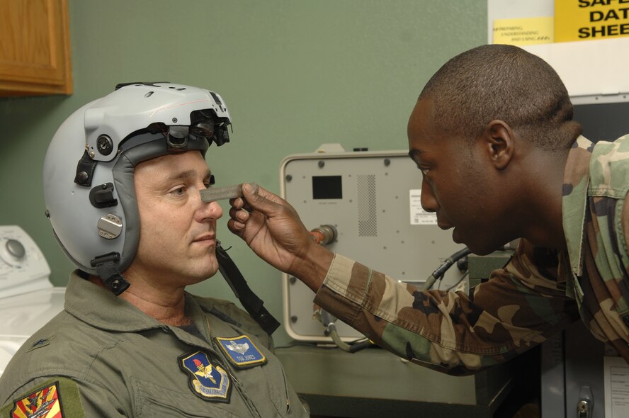 LEFT: Brig. Gen. Tom Jones, 56th Fighter Wing commander, is fitted for the new joint helmet mounted cueing system by Senior Airman Willis Austin, 310th Fighter Squadron Aircrew Life Support journeyman.  Each helmet costs approximately $110,000.  Photo by Master Sgt. William Gomez. 
