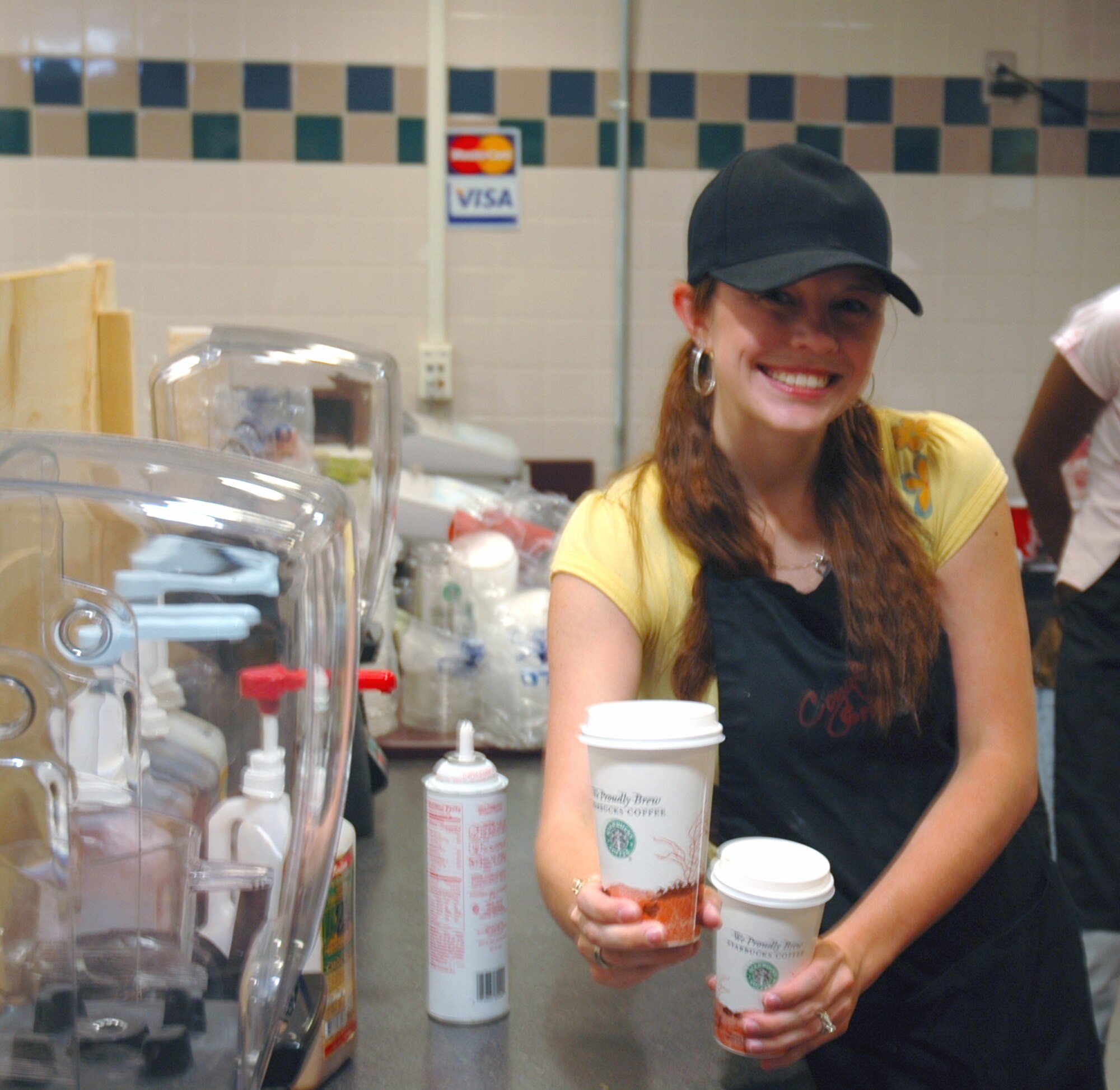 BUCKLEY AIR FORCE BASE, Colo. -- Ms. Tiffany Roy serves a freshly prepared mocha this morning during Starbucks' grand opening at Newtch's Den. Starbucks opens daily at 5 a.m. (U.S. Air Force photo by Staff Sgt. Sanjay Allen)