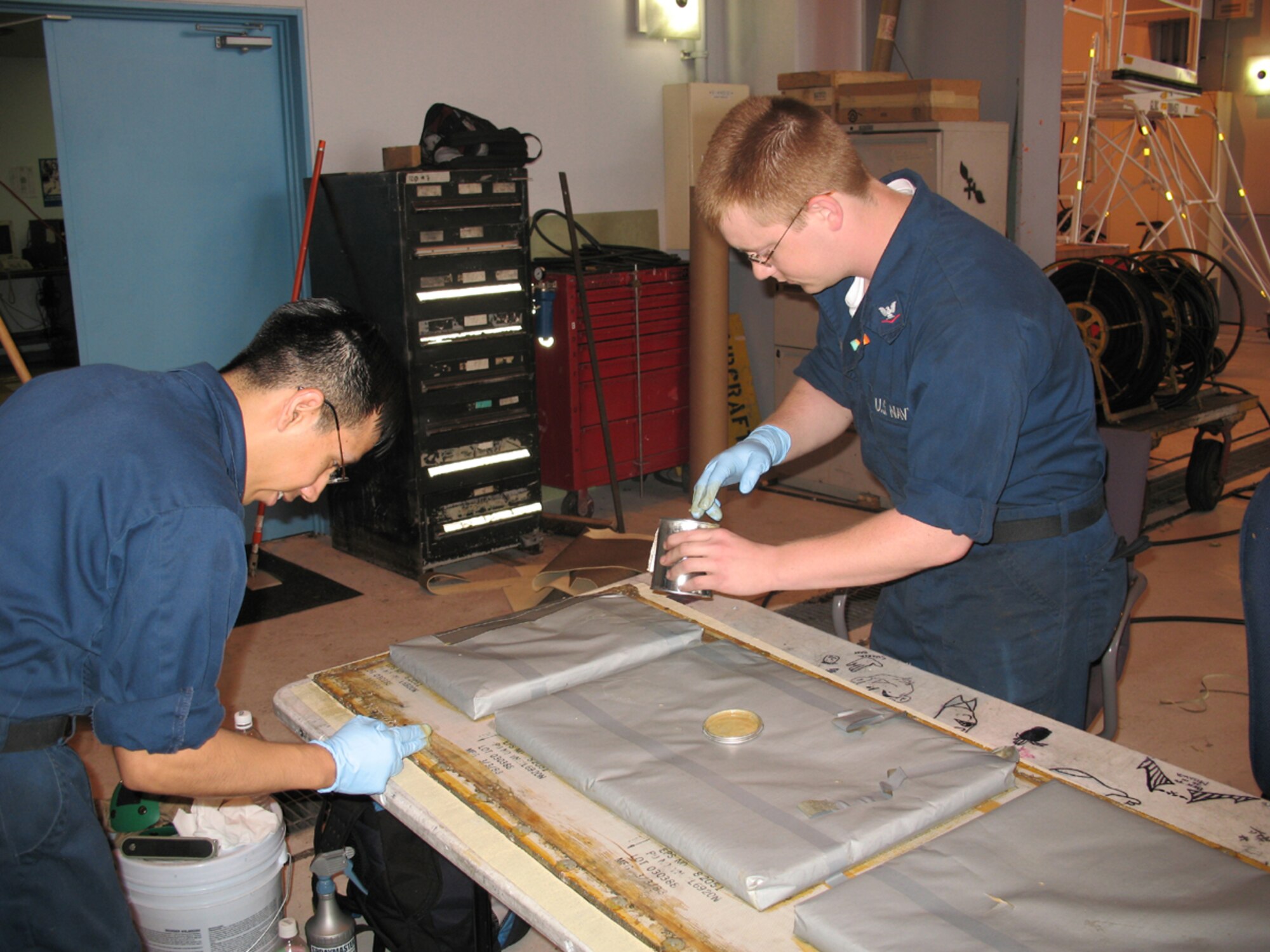 MISAWA AIR BASE, Japan -- Two P-3 Orion maintainers work on repairs to parts of the aircraft during its downtime.  P-3's can fly for about 90 days until they need to come to Misawa for repairs.  The process usually takes about 10 days to completely bring the P-3 back up to flying standards. (Photo by Senior Airman Sasha Navarro-Schmidt)