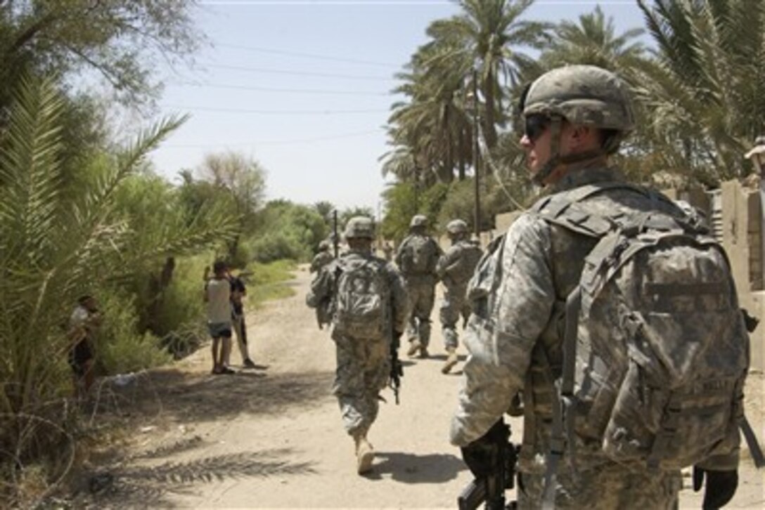U.S. Army soldiers of Bravo Company, 1st Battalion, 23rd Infantry Regiment, move in a column formation toward their next objective during a foot patrol in Baqubah, Iraq, July 21, 2007.  
