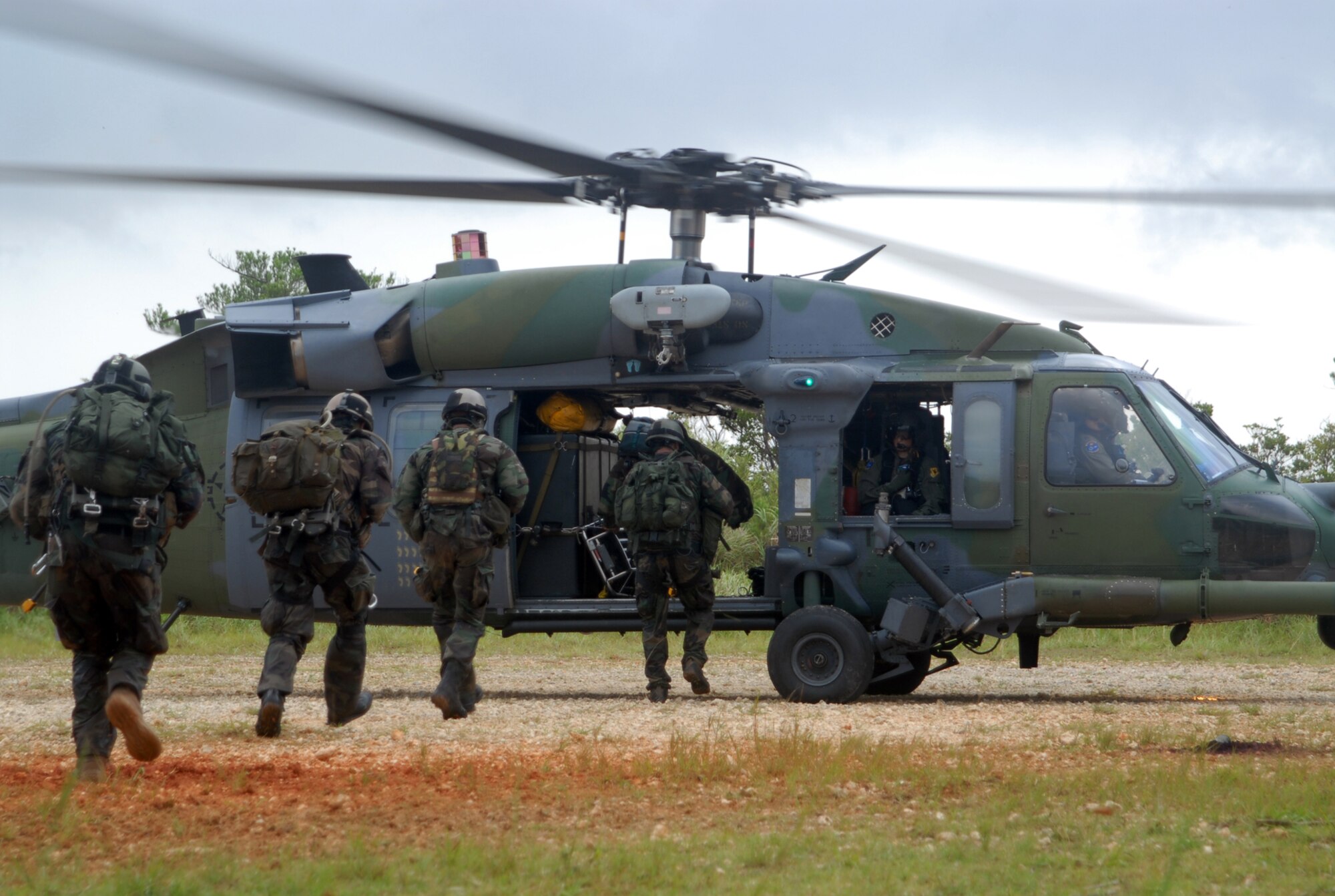 Pararescuemen from the 31st Rescue Squadron at Kadena Air Base, Japan, assist a survivor to an HH-60 Pave Hawk, while another helicopter monitors the area for enemy movement during a training exercise at Kadena July 23. The 31st RQS trained with Kadena’s other rescue squadron, the 33rd RQS, which operates the helicopters, in preparation for the 33rd's upcoming deployment to Kandahar, Afghanistan, to conduct combat search and rescue and medical rescue missions in support of Operation Enduring Freedom. The squadron is heading back to Afghanistan after returning from a four-month deployment to Kandahar in May. (U.S. Air Force Photo/Staff Sgt. Joshua J. Garcia)