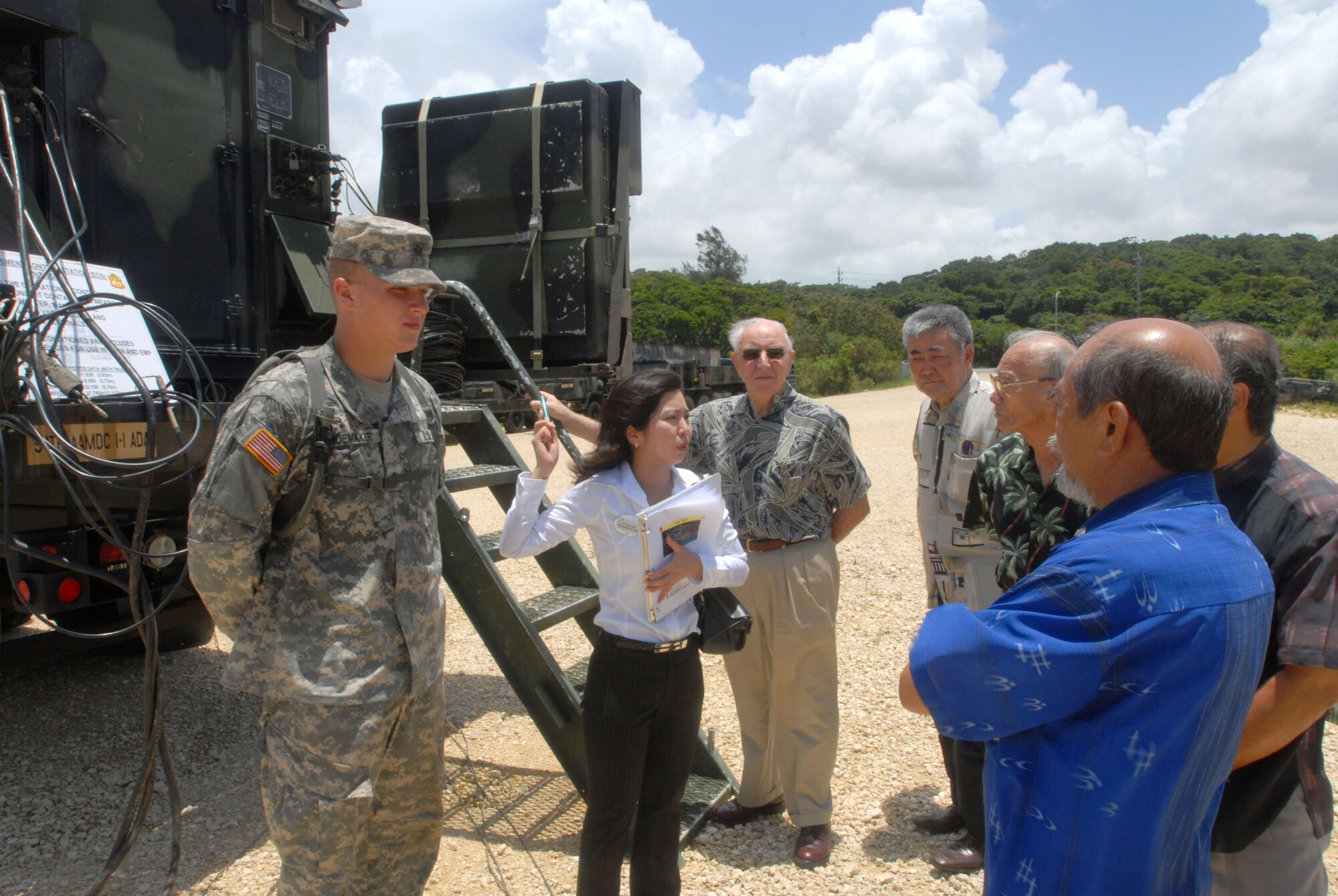 Okinawa business leaders get a close-up look at a U.S. Army Patriot battery system at Kadena Air Base, Japan, during a community relations tour July 16.  Army Pfc. Matthew Shoemaker, left, explained to the visitors the capabilities of the Army’s PAC-3 Engagement Control System operated by the 1-1 Air Defense Artillery Battalion, an associate unit at Kadena. Keiko Toma, center, of the 18th Wing Public Affairs Office, translates for the guests. This tour was part of the base’s co-commanders program in which senior leaders on Kadena are paired with local community leaders.  The program objective is to foster close relationships between the base and local communities, while promoting a better understanding of Kadena’s mission. Kadena’s leaders also gain insight into Okinawa public perspectives regarding U.S. and Air Force forces on Okinawa.  (U.S. Air Force/Senior Airman Darnell T. Cannady)