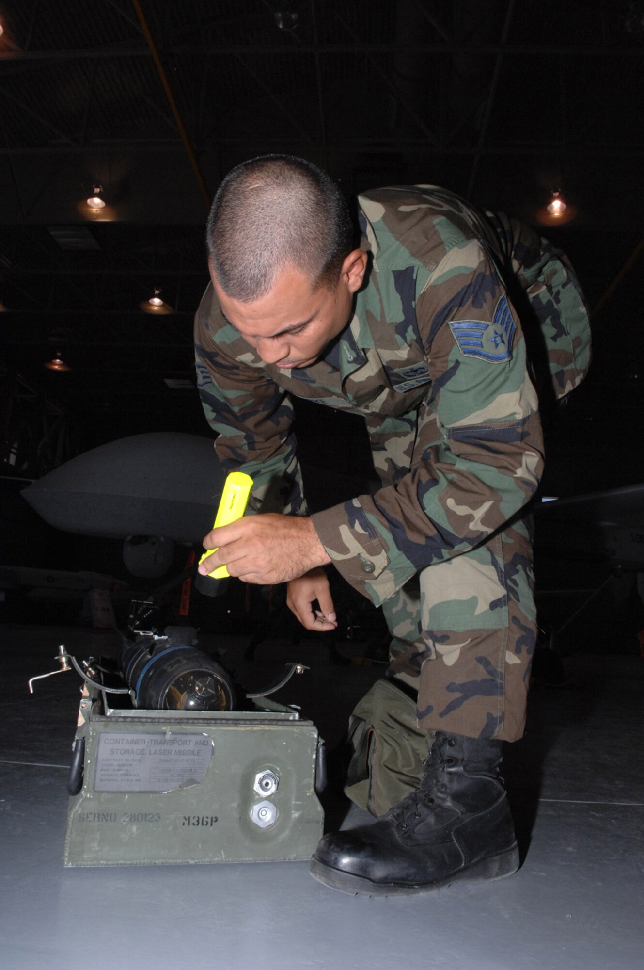 Air Force Staff Sgt. Kenneth Burke, a 57th Maintenance Group F-22A lead standardization crew member, inspects a replica of a AGM-114 Hellfire missile before loading it on the MQ-1 Predator during training July 18, 2007, at Creech Air Force Base, Nev. F-22A Weapons loaders from Nellis come to Creech every other month for proficiency training on loading missiles on the Predator. The original Predators, created more than a decade ago, did not have any weapon capability, nor were they satellite-controllable. Now, the new and improved predator is the most requested asset in theater.
(U.S. Air Force Photo by Senior Airman Larry E. Reid Jr.)

