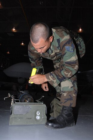 Air Force Staff Sgt. Kenneth Burke, a 57th Maintenance Group F-22A lead standardization crew member, inspects a replica of a AGM-114 Hellfire missile before loading it on the MQ-1 Predator during training July 18, 2007, at Creech Air Force Base, Nev. F-22A Weapons loaders from Nellis come to Creech every other month for proficiency training on loading missiles on the Predator. The original Predators, created more than a decade ago, did not have any weapon capability, nor were they satellite-controllable. Now, the new and improved predator is the most requested asset in theater.
(U.S. Air Force Photo by Senior Airman Larry E. Reid Jr.)
