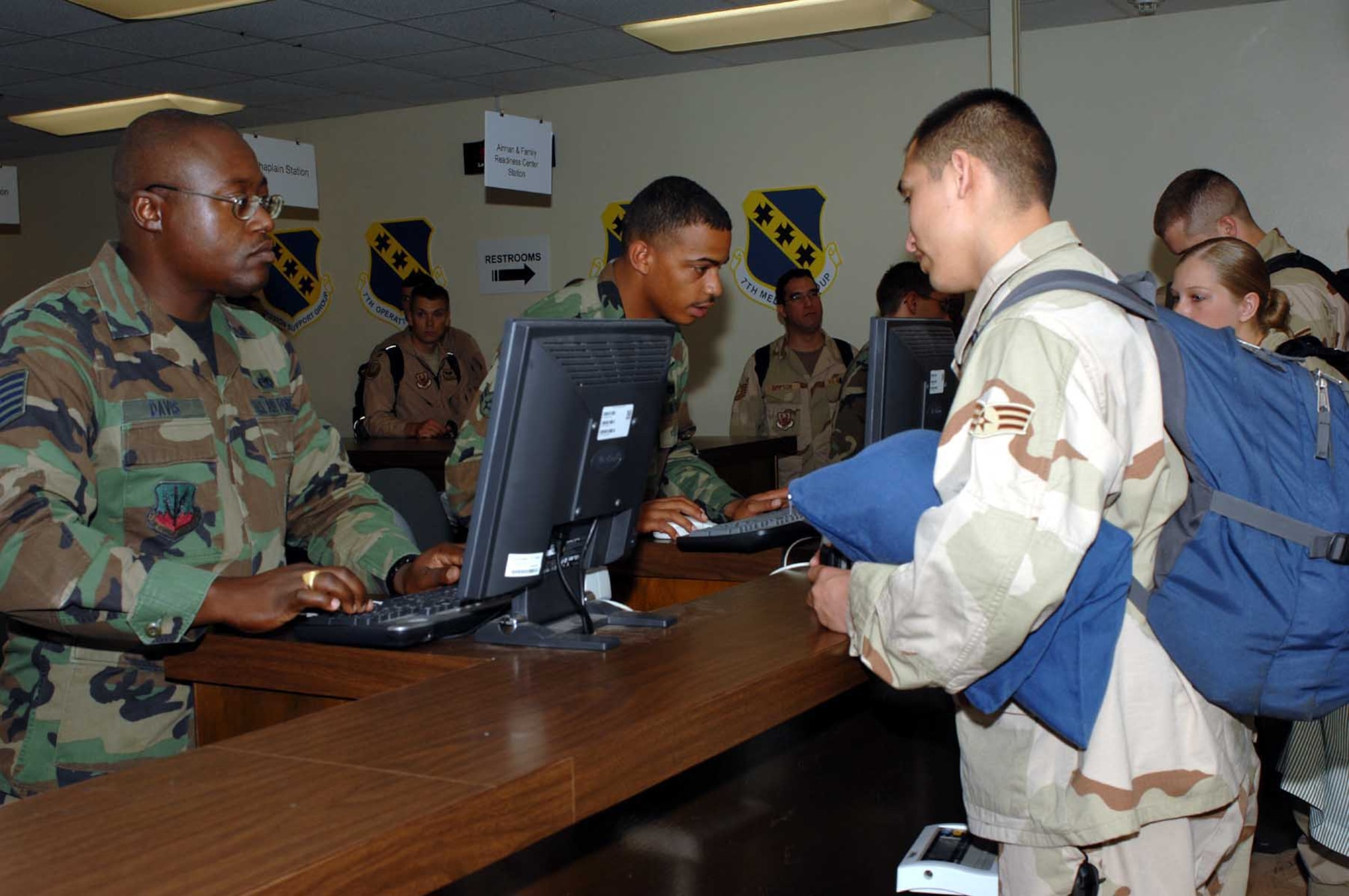 DYESS AIR FORCE BASE, Texas -- Tech. Sgt. Robert Davis, left, verifies Airman 1st Class Antone Grant's personal information at the passenger manifest station before flight check-in for deployment June 20. (U.S. Air Force photo/Senior Airman Courtney Garrard)