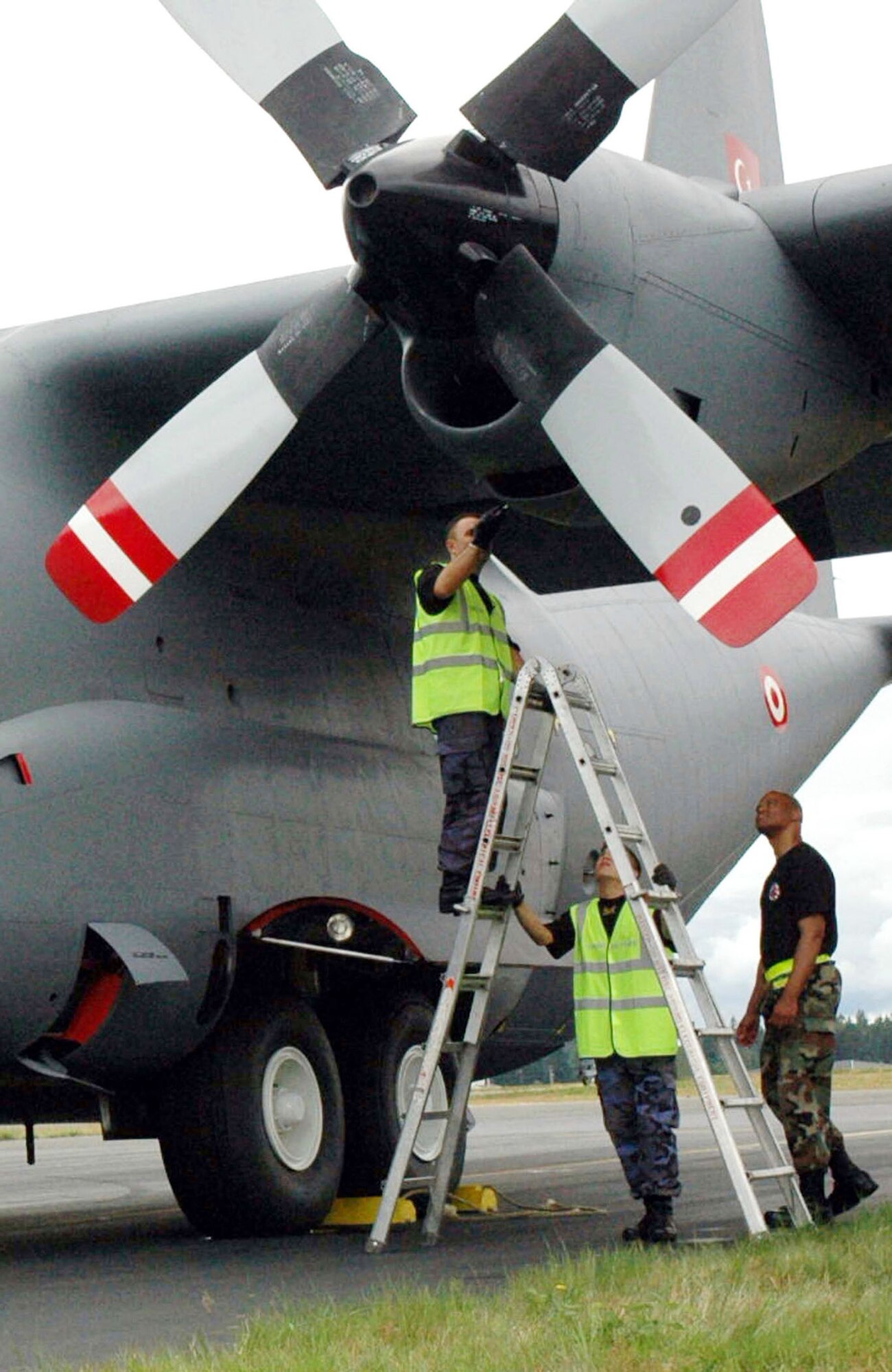 Tech. Sgt. Trey Woodward (right) and two Turkish maintainers make a final check of an engine on a Turkish C-130 that required repair.  The Turks, with assistance from Sergeant Woodward and other Airmen from the 446th Aircraft Maintenance Squadron at McChord Air Force Base, Wash., worked non-stop to repair the engine and get the aircraft ready for its first competition flight at Air Mobility Command's Rodeo 2007.  (U.S. Air Force Photo/Staff Sgt. Nick Przybyciel)