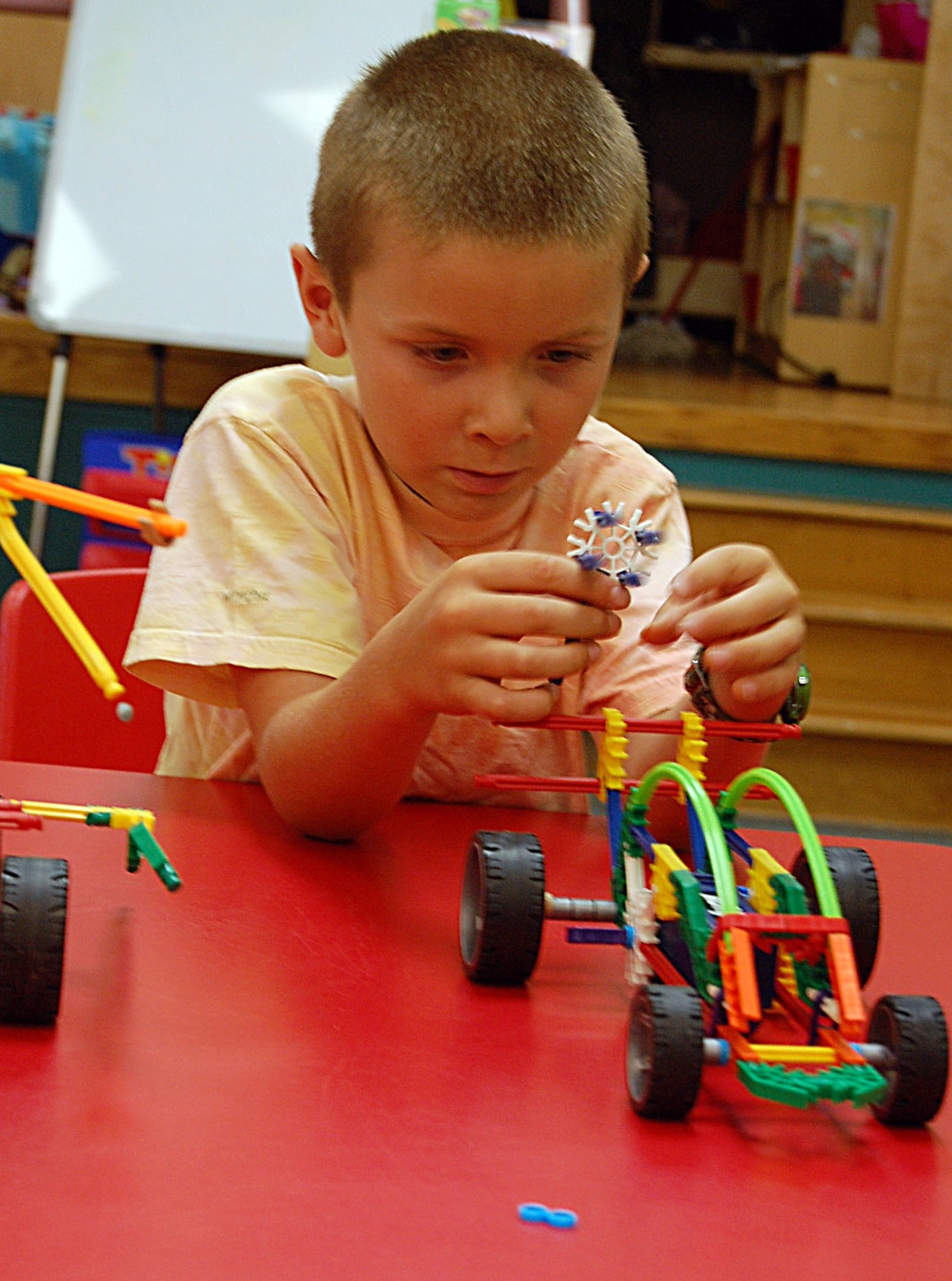 LAUGHLIN AIR FORCE BASE, Texas -- Jacob Beineke, son of Lt Col. Cheryl Beineke, 86th Flying Training Squadron, and Lt. Col. Paul Beineke, 47th Operation Support Squadron, concentrates on building his makeshift car to learn what elements make an actual car move. (U.S. Air Force photo by Airman Sara Csurilla) 