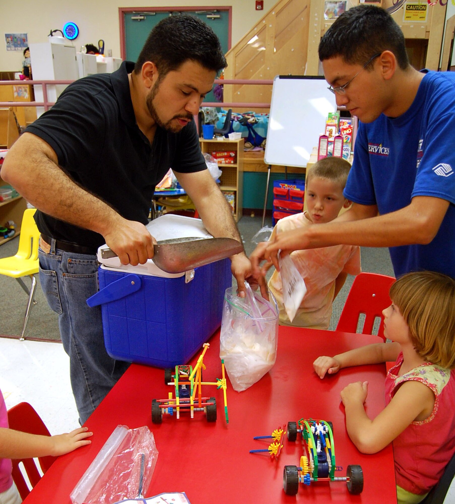 LAUGHLIN AIR FORCE BASE, Texas -- Mr. Oscar Hernandez, Science Adventure Camp instructor, and Mr. Albert Alvarado, Youth Center staff member,  put ice in a plastic bag for children in the Science Adventure Camp in order to help them make homemade ice cream. Science Adventures is a week-long specialty camp that is held once a year at Laughlin?s Youth Center to teach children different things about science. (U.S. Air Force photo by Airman Sara Csurilla)