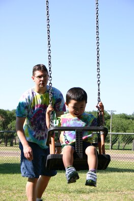 Staff Sgt. David Aten, 27th Communications Squadron, pushes his son Connor on a swingset at Unity Park. Sergeant Aten adopted Connor from China in January. (U.S. Air Force photo by Airman Elliott Sprehe)