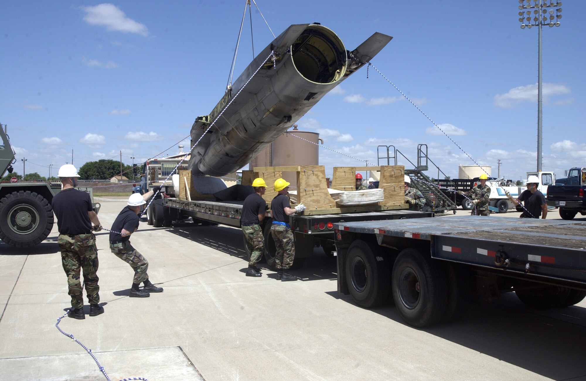 Airmen work on lifting the fuselage of an F-16 off the trailer of a truck so it can be moved to the trailer in the foreground. The F-16, which was originally from Sheppard Air Force Base, Texas, will become a static display at the air park near the main gate.  (U.S. Air Force photo by Airman Elliott Sprehe)