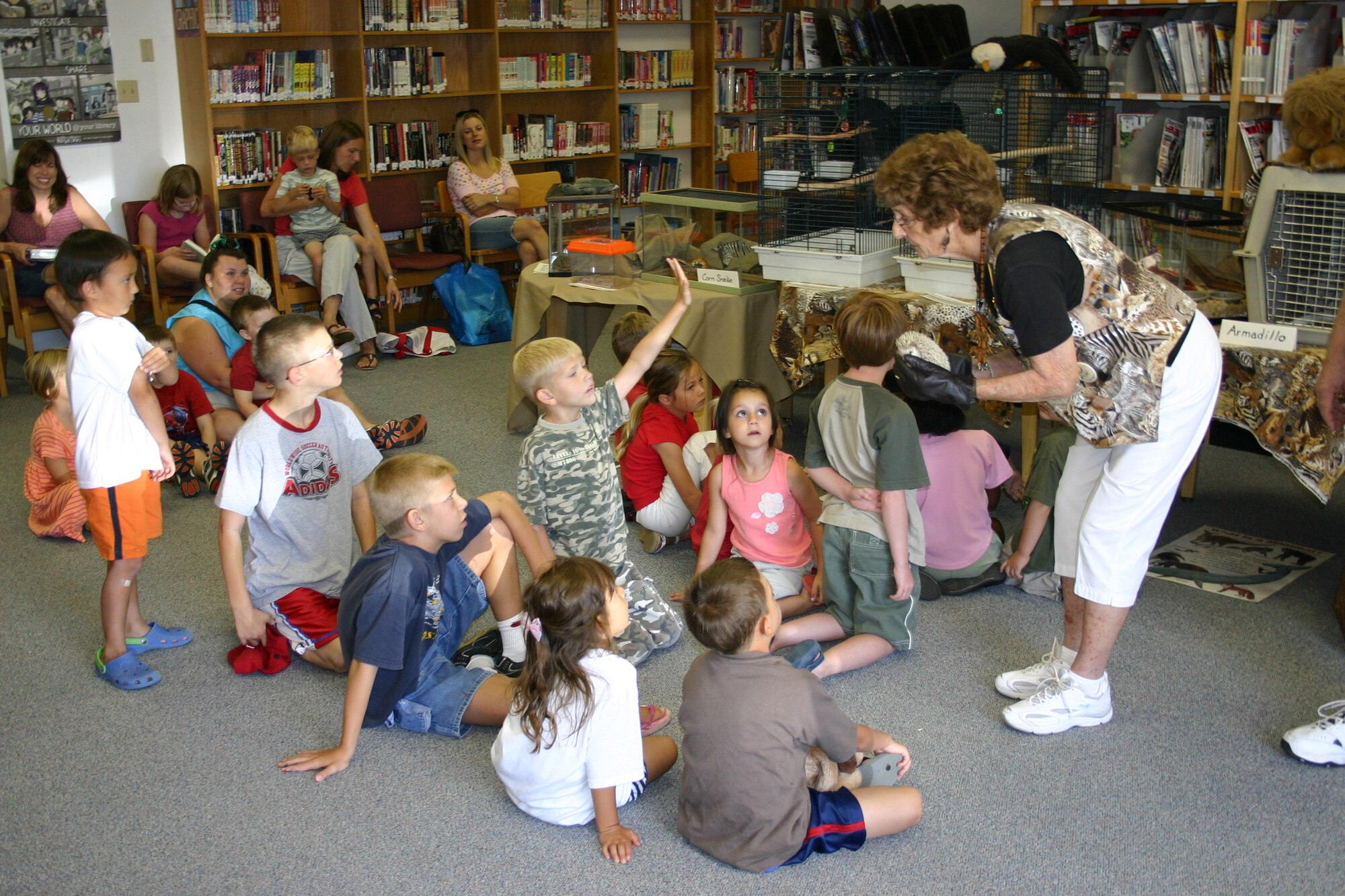 Joyce Connors, with the Albuquerque Bio Park, holds a hedgehog as a child asks a question. The Albuquerque Zoo brought out reptiles, amphibians, birds and mammals as part of the "Catch the Beat" program at the library. (U.S. Air Force photo by Airman Elliott Sprehe)