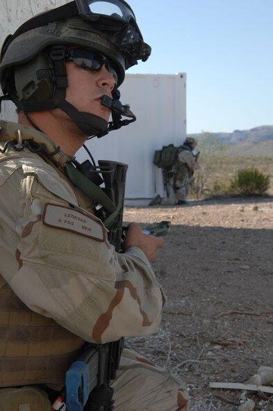 Capt. Eric Lederer, 48th Rescue Squadron, combat pararescue officer, gives information for a call for fire as his fellow rescueman provide cover during exercise Angel Thunder. Angel Thunder is a combat search and rescue task force exercise designed to test theater spin-up capabilities and examine the integration of all Air Force assets in mission planning procedures and mission execution. (U.S. Air Force photo/Staff Sgt Lanie McNeal)