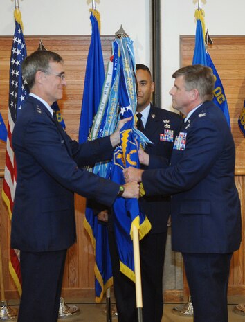 Maj. Gen. Michael Worden, the U.S. Air Force Warfare Center commander is passing the flag to Col. Mark Koechle, the new commander of the 98th Range Wing. (Air Force photo by Airman 1st Class Ybarbo)