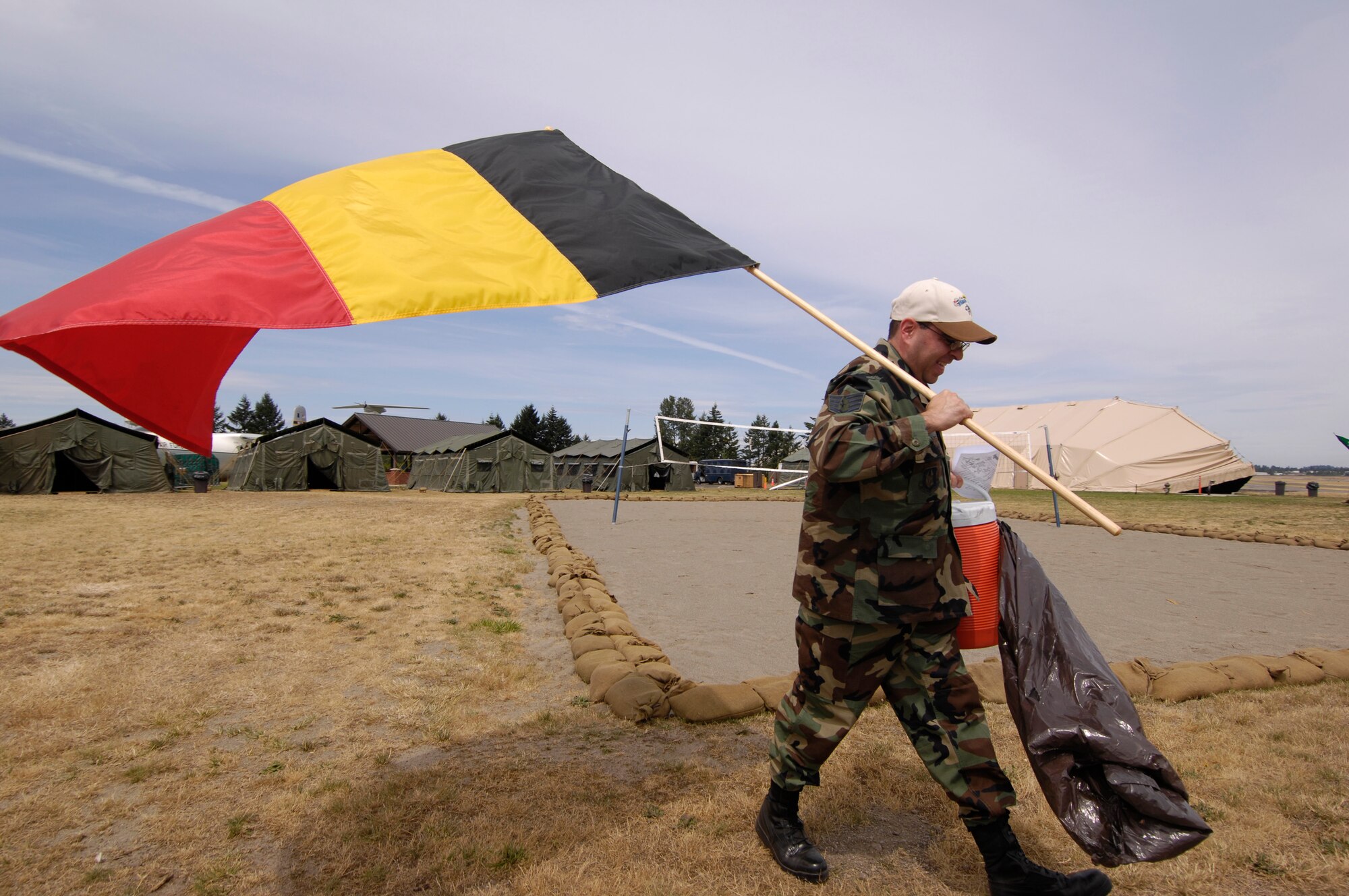 Staff Sgt. John Lewis carries a Belgium flag to its designated tent for Air Mobility Rodeo 2007, hosted by Air Mobility Command, July 16. Rodeo is a readiness competition of U.S. and international mobility forces.  It focuses on improving warfighting capabilities and support of the Global War on Terrorism.
( U.S. Air Force Photo/Staff Sgt Samuel Bendet) 

