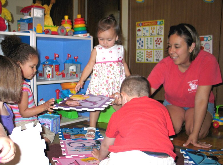 FAIRCHILD AIR FORCE BASE, Wash. – Brianna Evans (far right), Family Child Care provider here, gets down to the floor level with her daycare children. Ms. Evans, who has been a Fairchild provider for one-and-a-half years, watches a total of 11 children throughout the week, including her own two daughters. Of the daycare business, she said she has “fallen into this hard … I love it!” (U.S. Air Force photo/ Staff Sgt. Connie L. Bias)